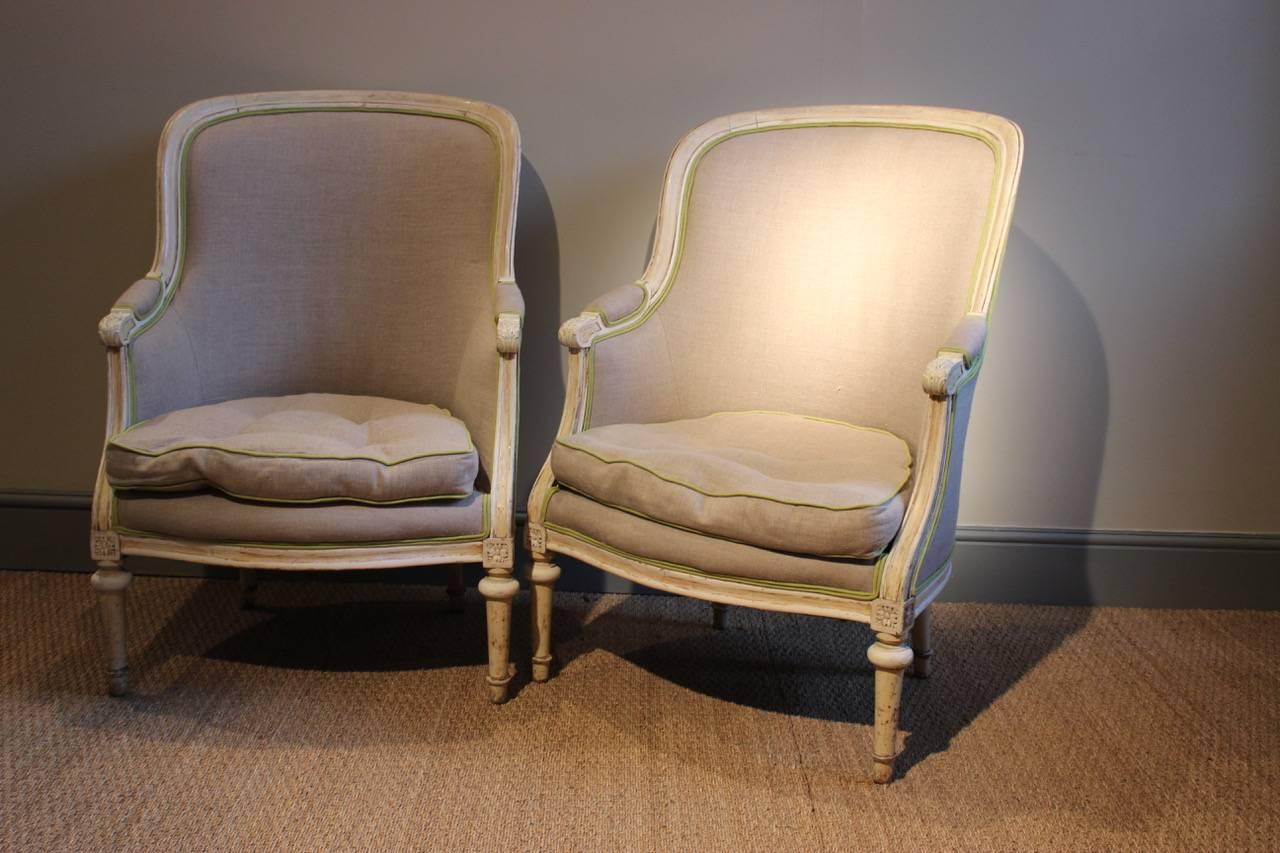 An elegant pair of 19th century French painted armchairs in the Louis XVI style, re-upholstered by us in a neutral linen with contrasting piping. 

Measures: Seat height: 46 cm.
  