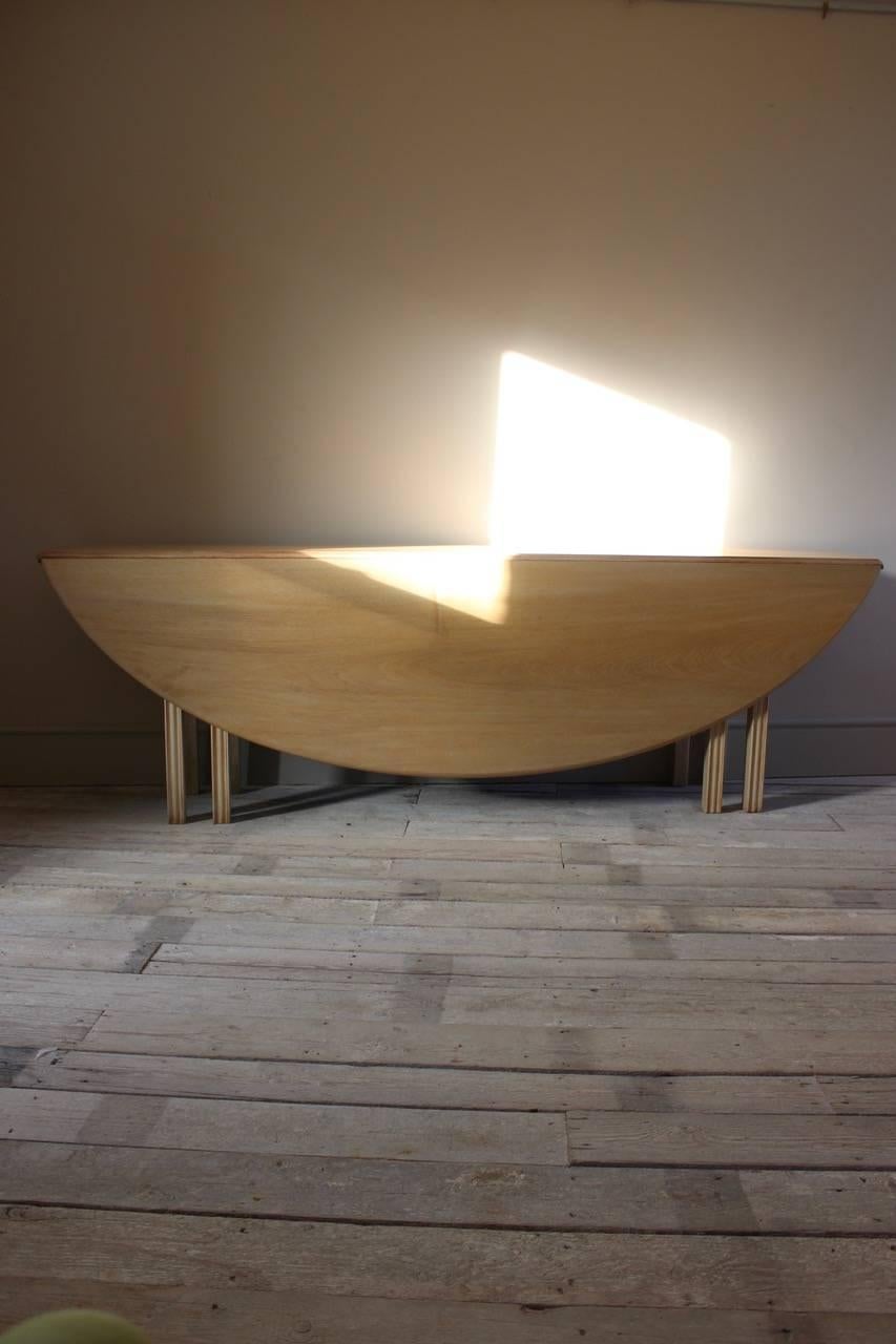 A large circa 1950s bleached mahogany folding oval dining table of Irish 'hunt' or 'wake' style.

Measures: Depth: 42cm deep (closed) x 162cm deep (open).

  