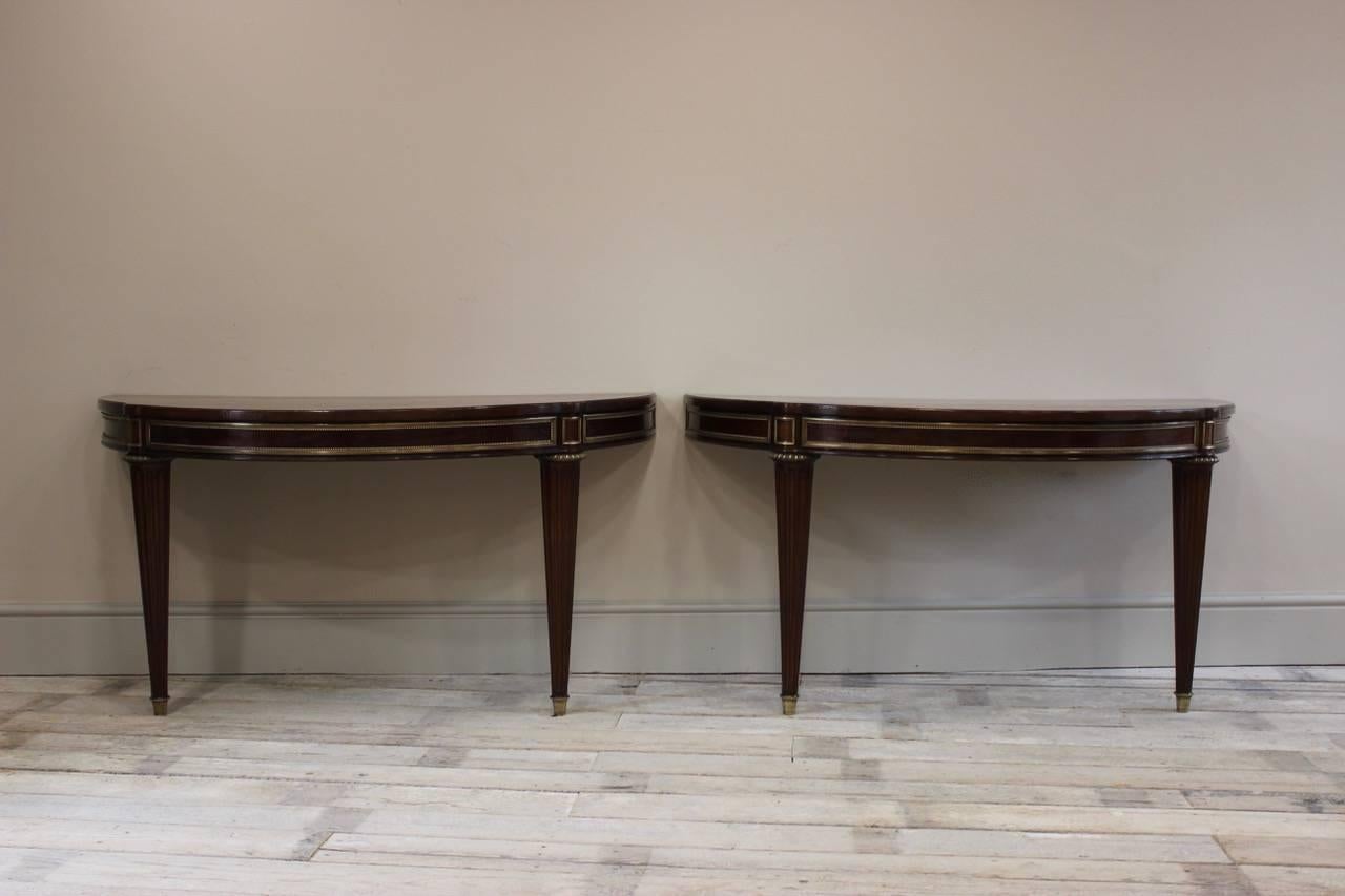 A fine quality pair of gilt bronze-mounted mahogany and inlaid D-end side or console tables in the Louis XVI style, French, mid-20th century.