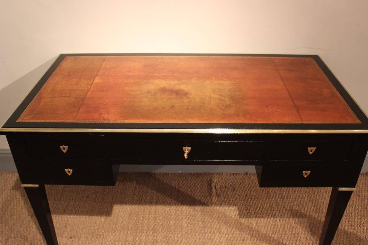 A very stylish and decorative French brass-mounted and ebonized bureau plat or desk with inset tooled leather top, and two brushing slides in the Louis XVI taste, that will work very well in a contemporary setting, circa 1900-1920s 

Width