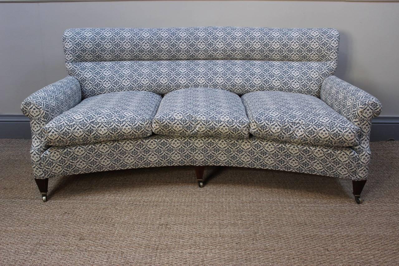 A very elegant and comfortable 1950s English country house sofa by Howard and Sons, of unusual curved from, having been recently reupholstered in their monogrammed calico covering.
 