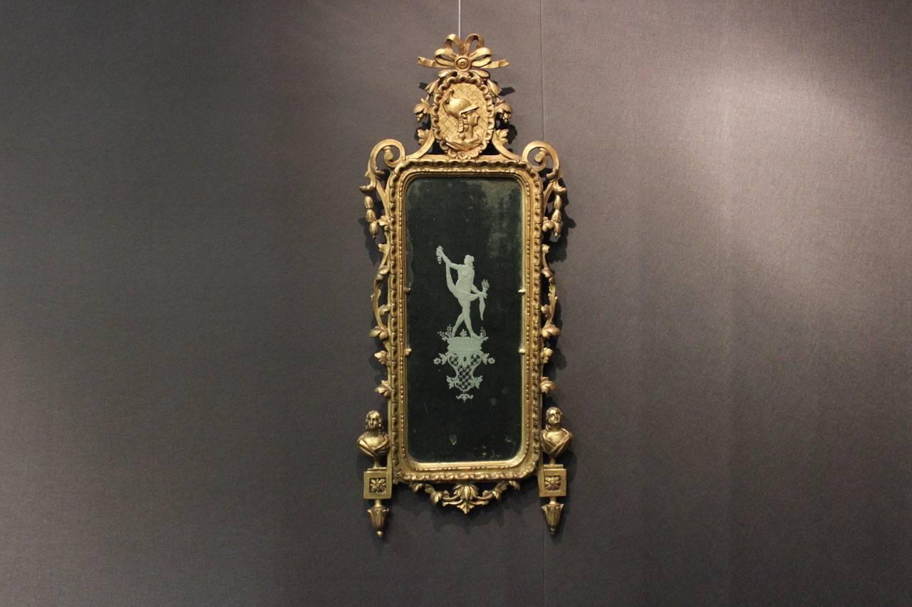 A fine and decorative 18th century Venetian giltwood mirror with its original engraved glass mirror-plate centered by a classical female figure.
 