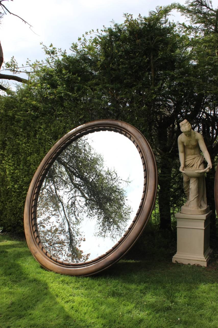 A very unusual pair of very large 19th century oval frames in walnut, in the classical taste, with later distressed mirror plates, that will make a statement in any setting. 

This elegant and large pair is the biggest pair of mirrors that we have