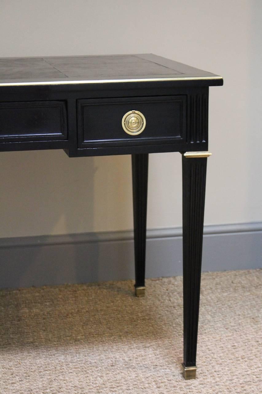 A very stylish late 19th century French ebonized desk, double faced with bronze mounts, and retaining the original leather top.