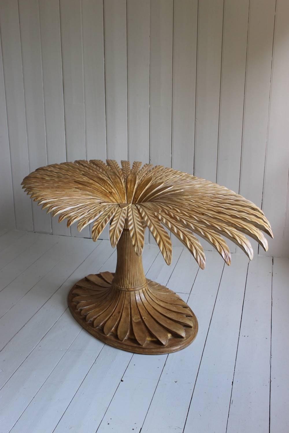 An unusual Italian carved and partially gilded pine centre table with an oval glass top, the base naturalistically carved as a bound wheat-sheaf, circa 1970s.