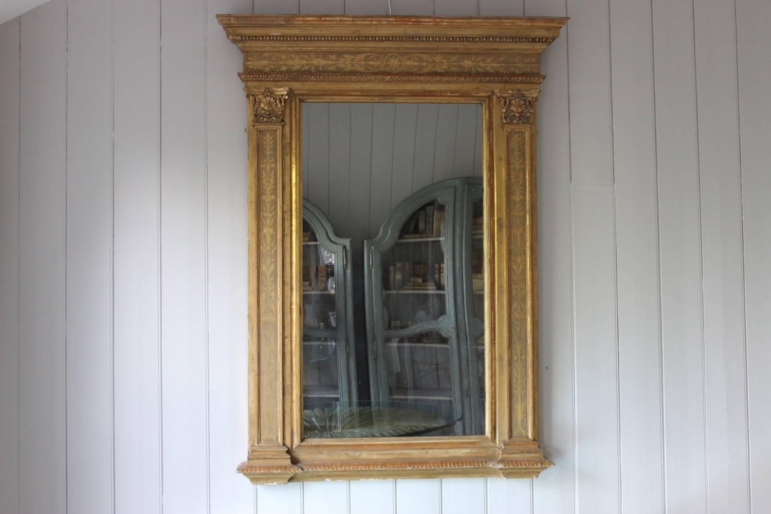 A Fine quality giltwood and cut-gesso overmantel or pier mirror of restrained architectural form but rich in carved and engraved ornamentation, with its original rectangular plate, French or Italian, late 19th century.