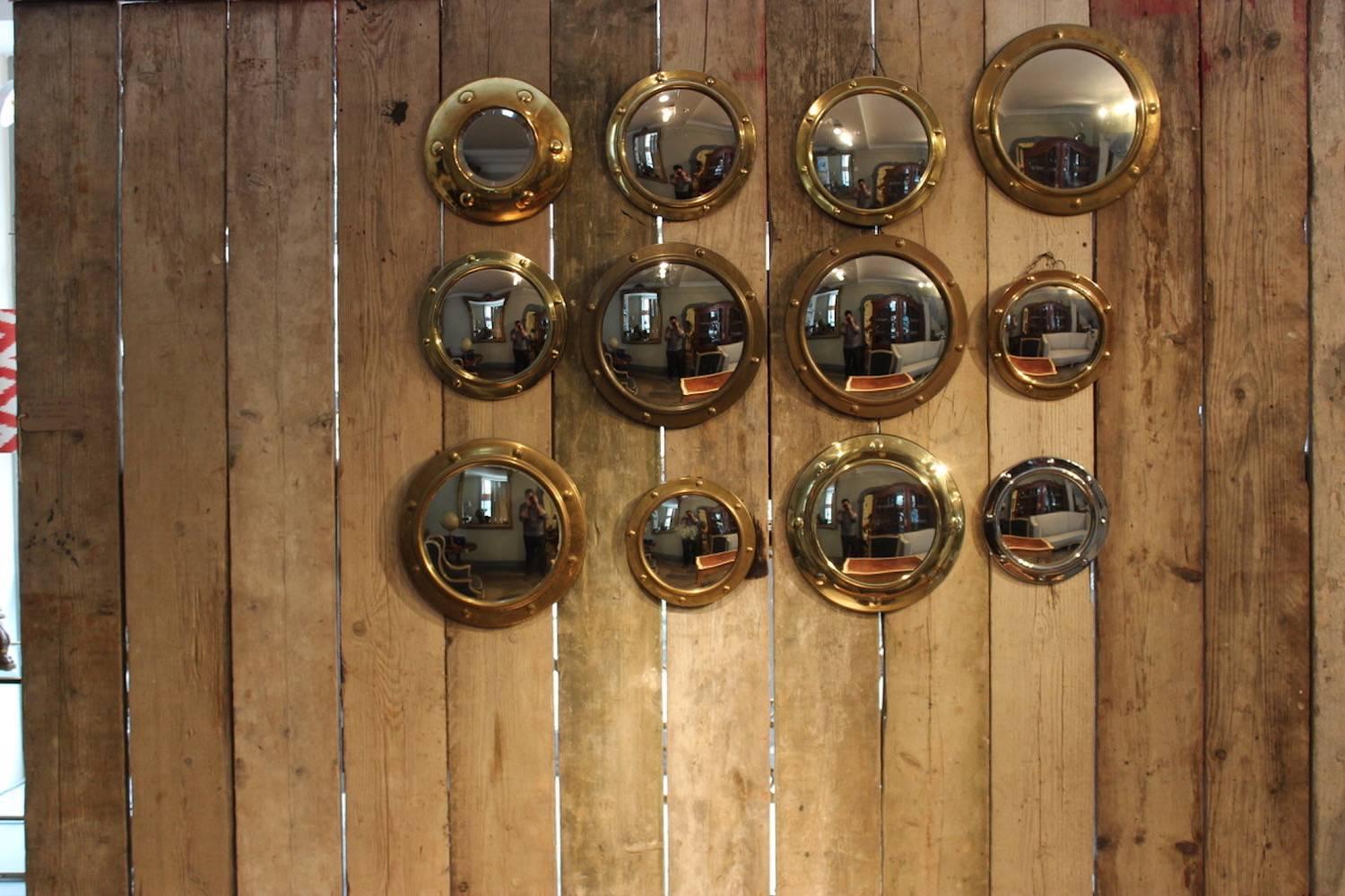 A collection of 12 variously sized English brass porthole mirrors with riveted detail to the frame and circular glass plates, the largest 39cm diameter, the smallest 27cm diameter, circa 1930s and later.