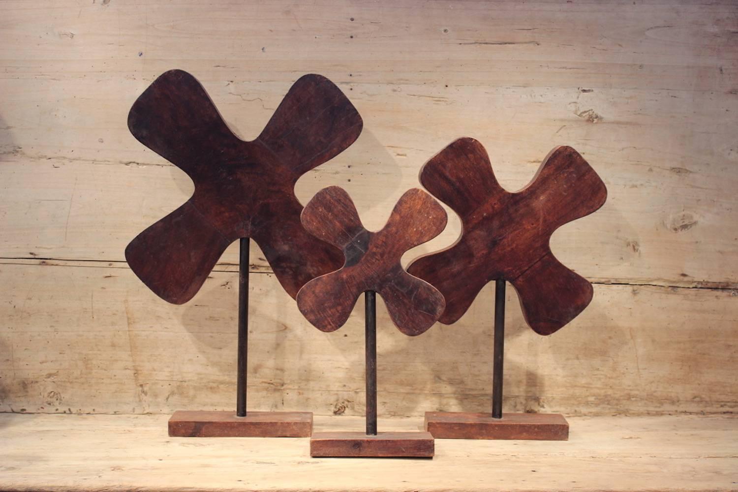A funky and graphic set of three hardwood abstract profile moulds, mounted on wooden bases, the largest 65cm high, the smallest 45cm high, France, 1960s.