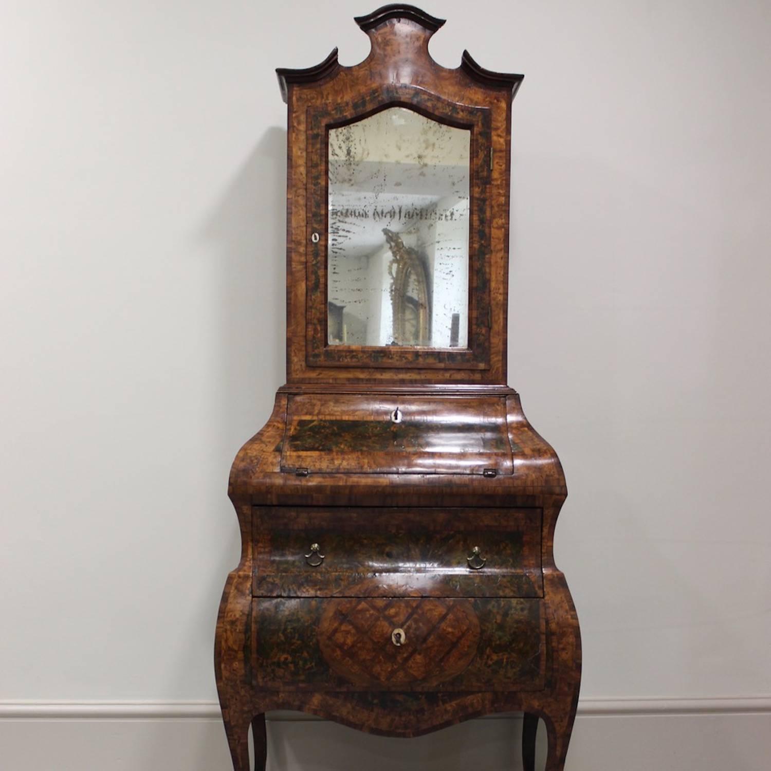 A charming and neatly-proportioned North European walnut and parquetry ladies bureau cabinet, the arched door of the upper section retaining its original glass plate, probably German or Italian, mid-18th century.