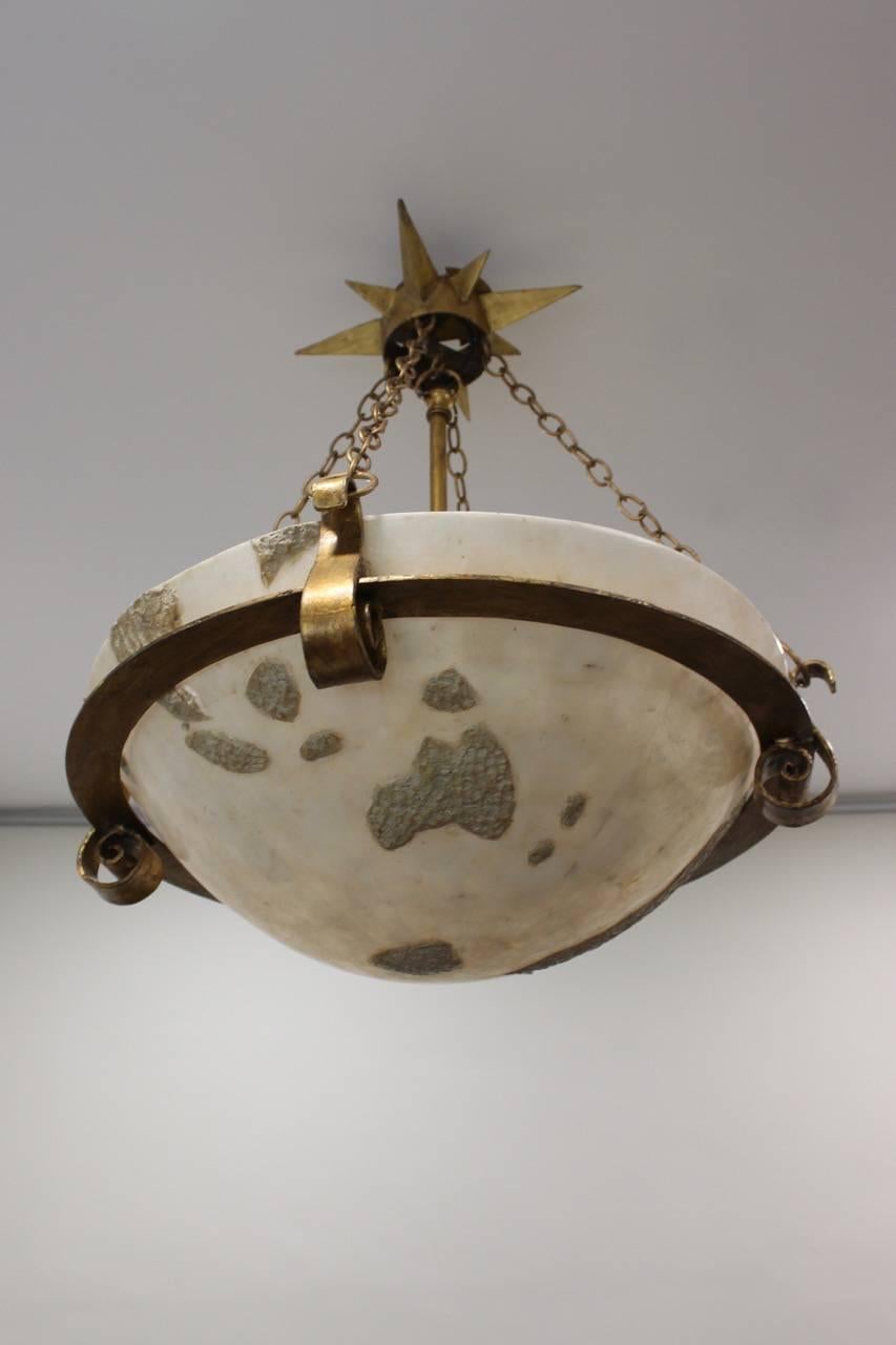 An unusual and highly decorative mid-20th century gilt wrought metal and moulded fibreglass ceiling light, with original stellate patrice and suspension chains, the shade with raised plaster geographical motifs, European, circa 1960s-1970s.