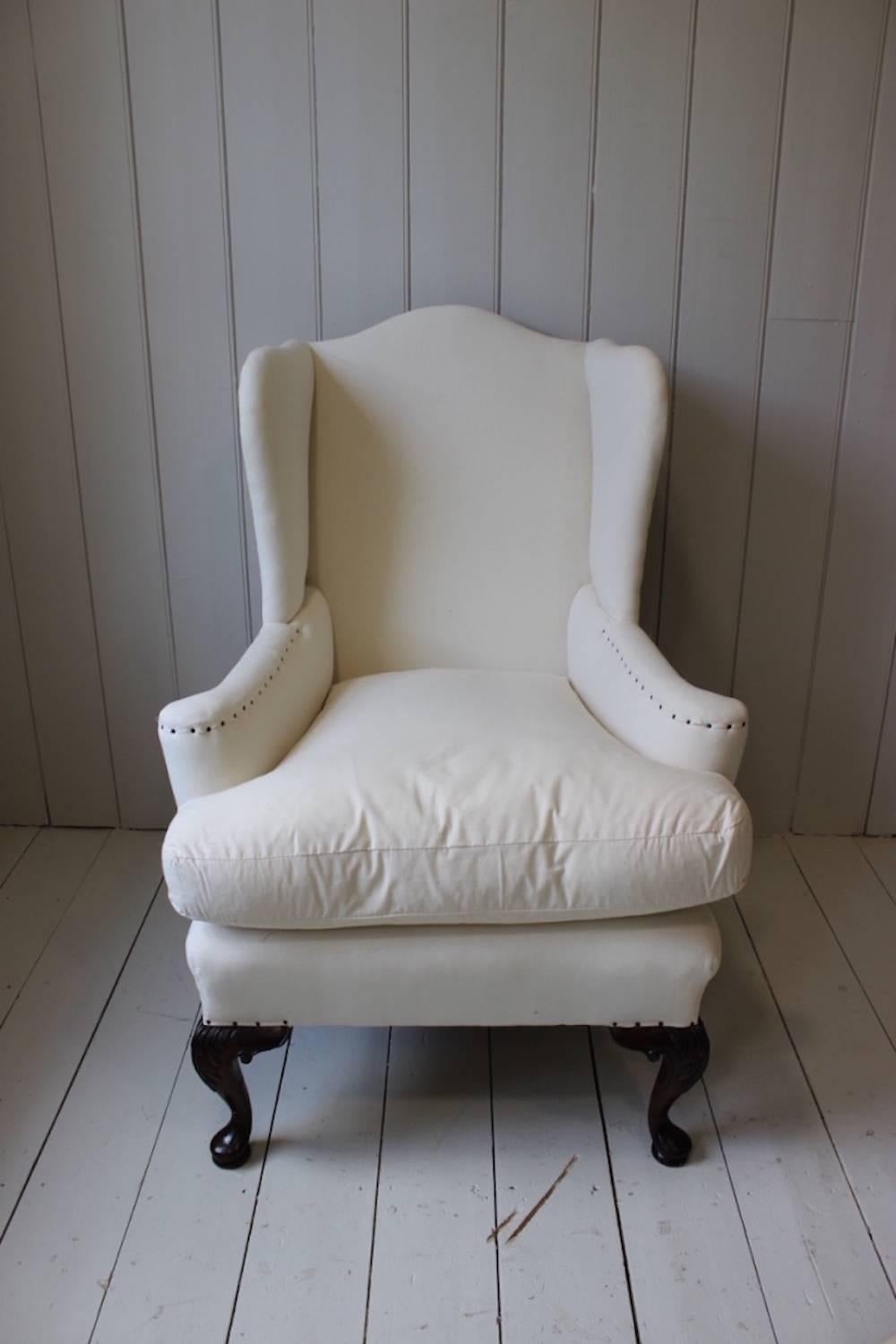 A fine quality 19th century carved mahogany wing armchair in the mid-Georgian style, re-upholstered by us in a unique combination of hessian and calico, with a feather-filled squab cushion