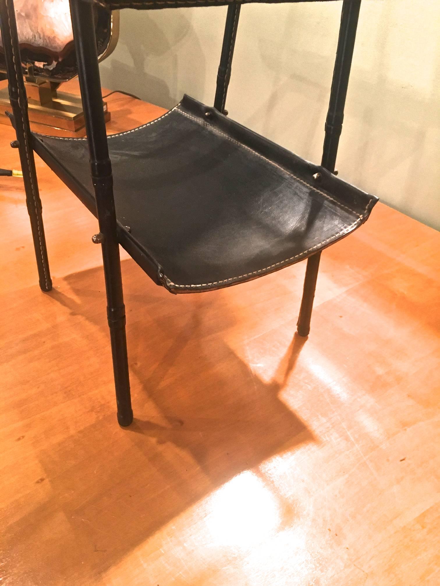Jacques Adnet two-tier side table and magazine rack in black leather.