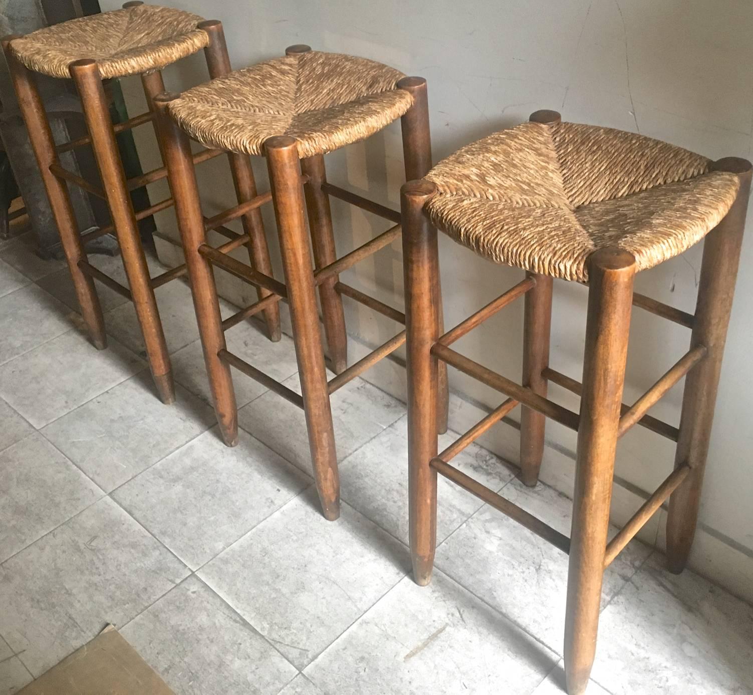 Charlotte Perriand, set of three rush bar stools, circa 1950.
      