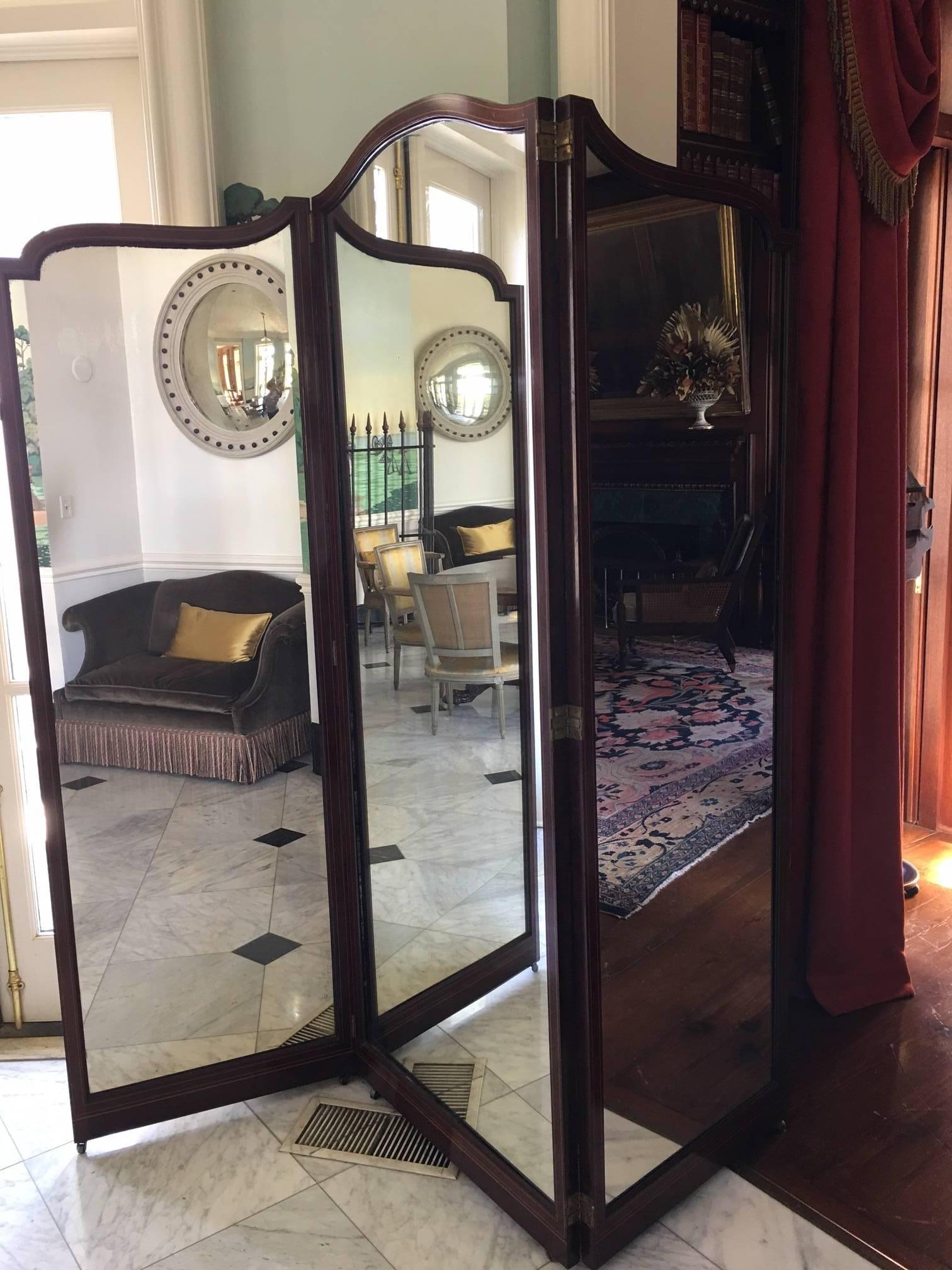Three-panel folding mahogany screen with dual inlay. The back was upholstered in damask, now needing replacement. Brass casters and hinges.
Good antique condition.

Fabric on back needs replacement.

The two side panels are 24 1/2