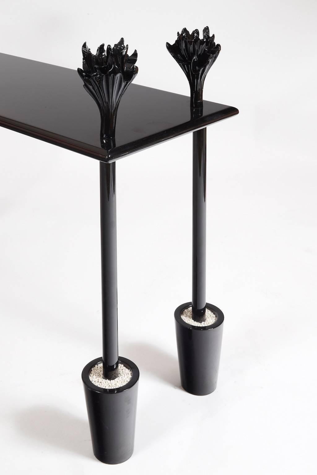 Leg in shape of four bushes, with stylized foliage, in conical pots filled with white gravel.
Made of black polypropylene.
