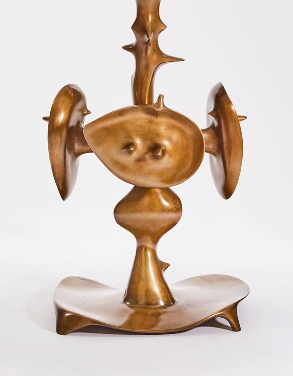Pedestal table composed by a bronze leg with a surrealist ornamentation mounted by a white marble circular plate.