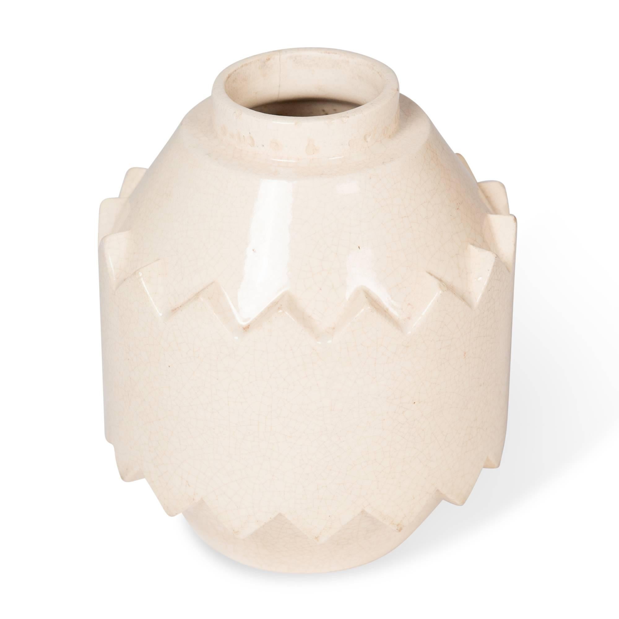 Beige crackle glaze ceramic vase, of cylindrical form and chevron sawtooth edge raised centre band, by Robert Lallemant, France 1930s. Signed to underside. Measures: Height 8 in, diameter 6 in.

Note: Some edgewear, hairline crack. See