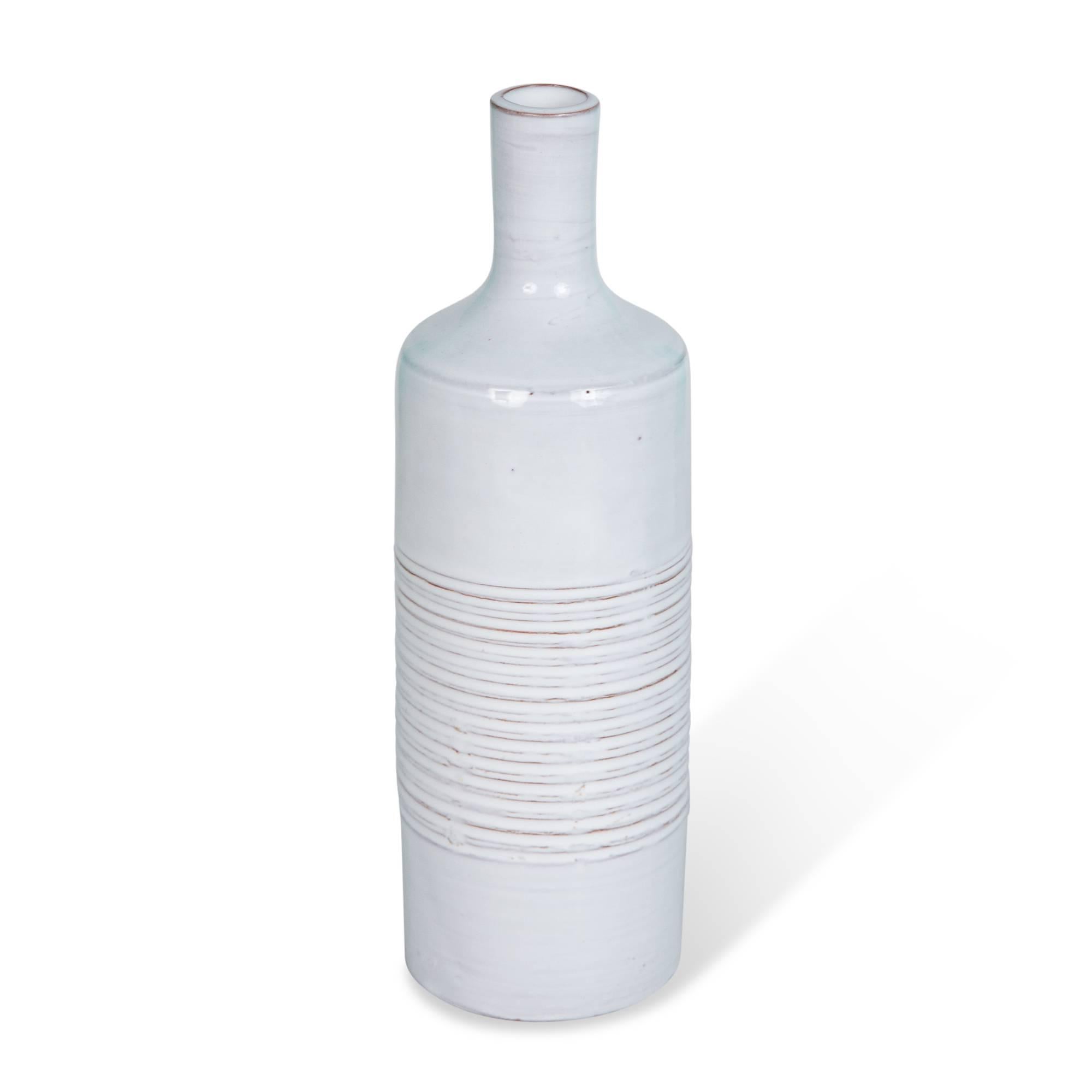 Grey-white bottle form ceramic vase, with long neck, and grooved bands in center of body, by Les Argonautes, France, 1950s. Measures: Height 9 in, diameter 2 3/4 in. (Item #5081).
  