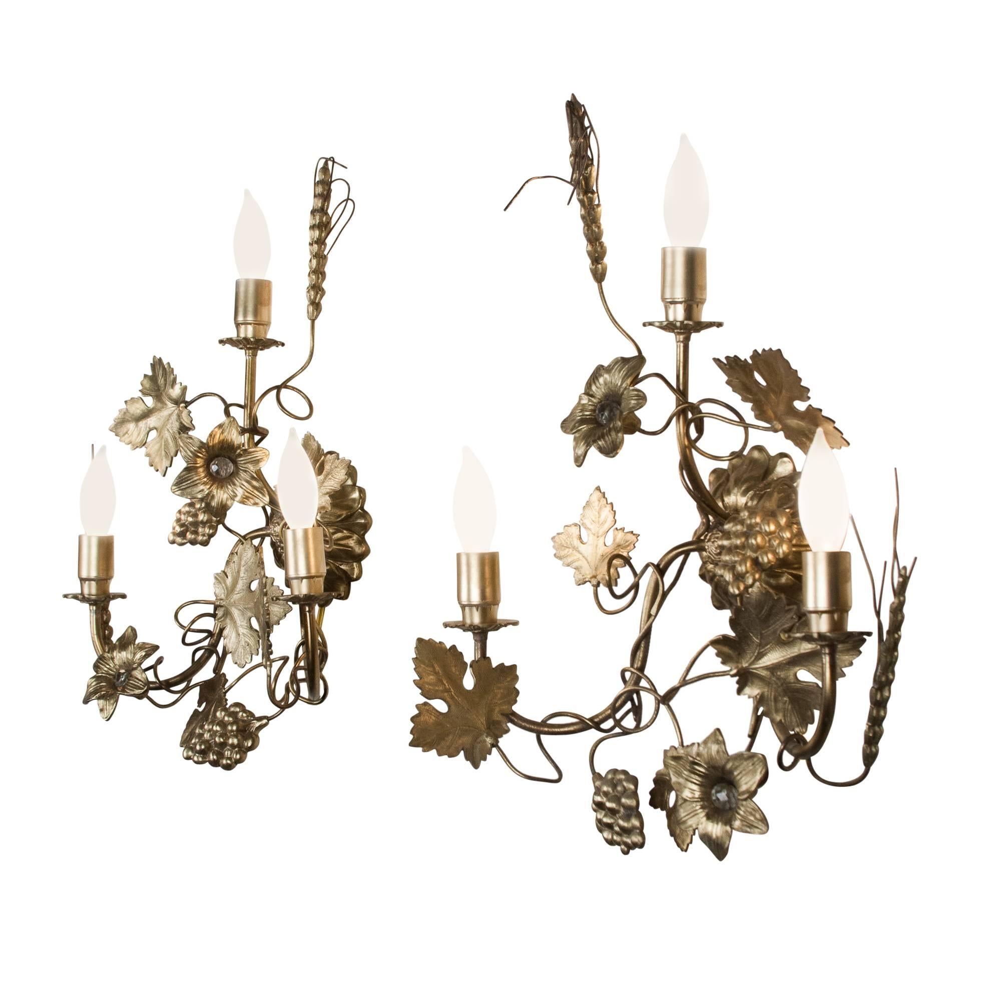 Pair of three-light gilded metal sconces, grape vine, flower and leaf ornamentation, French, 1960s. Measures: Height 17 in, width 13 in, depth 6 in. 