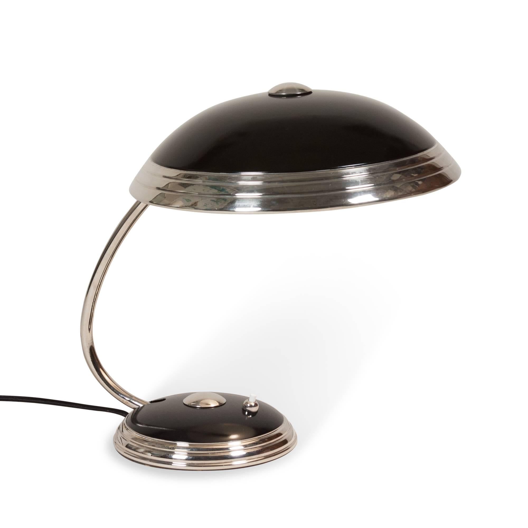 Chrome and black lacquered metal dome desk lamp, the shade as well as the arm pivoting up and down, by Helo, German, 1950s. Signed to underside. Measures: Height 14 in, diameter of shade 12 1/4 in.