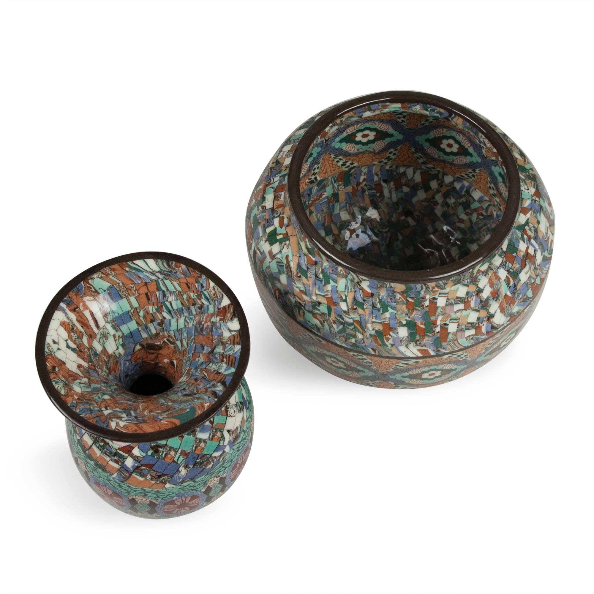 Two vases:
1) Flared neck ceramic vase, the form built by ceramic mosaic elements in colors of blue, grey, black, rust, green and white, by Atelier Gerbino, Vallauris, France, 1980s. Stamped signature to underside. Height 7 1/4 in, diameter 5 1/4