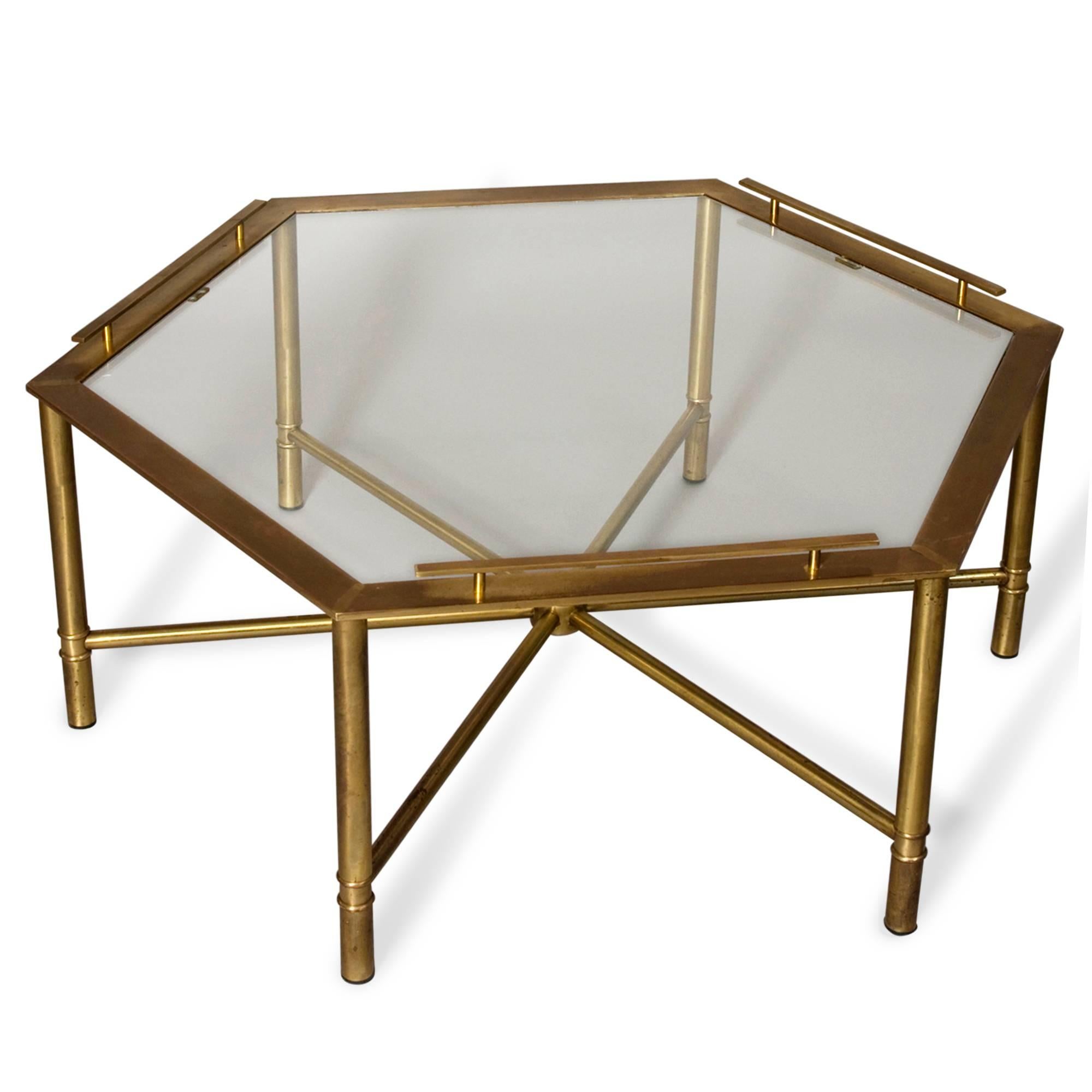 Bronze hexagonal shaped coffee table, with glass top, on six legs having stretchers meeting in center, and three of six sides of hexagon having raised gallery type edge, by Mastercraft, American 1970s. Distance from point to point 42 in, distance