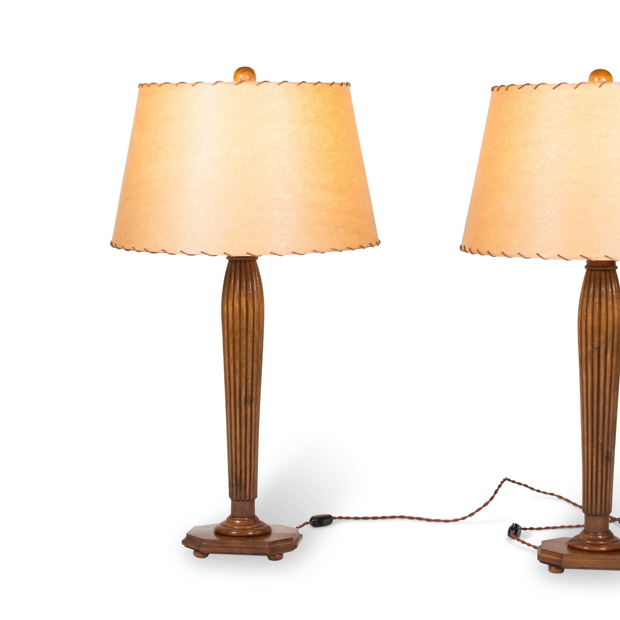 Pair of fluted and tapered column fruitwood table lamps, the column resting on rectangular base with ball feet, in custom stitched parchment paper shades and having wood ball finial, Italian 1960s. With paper label to underside from Rome gallery.