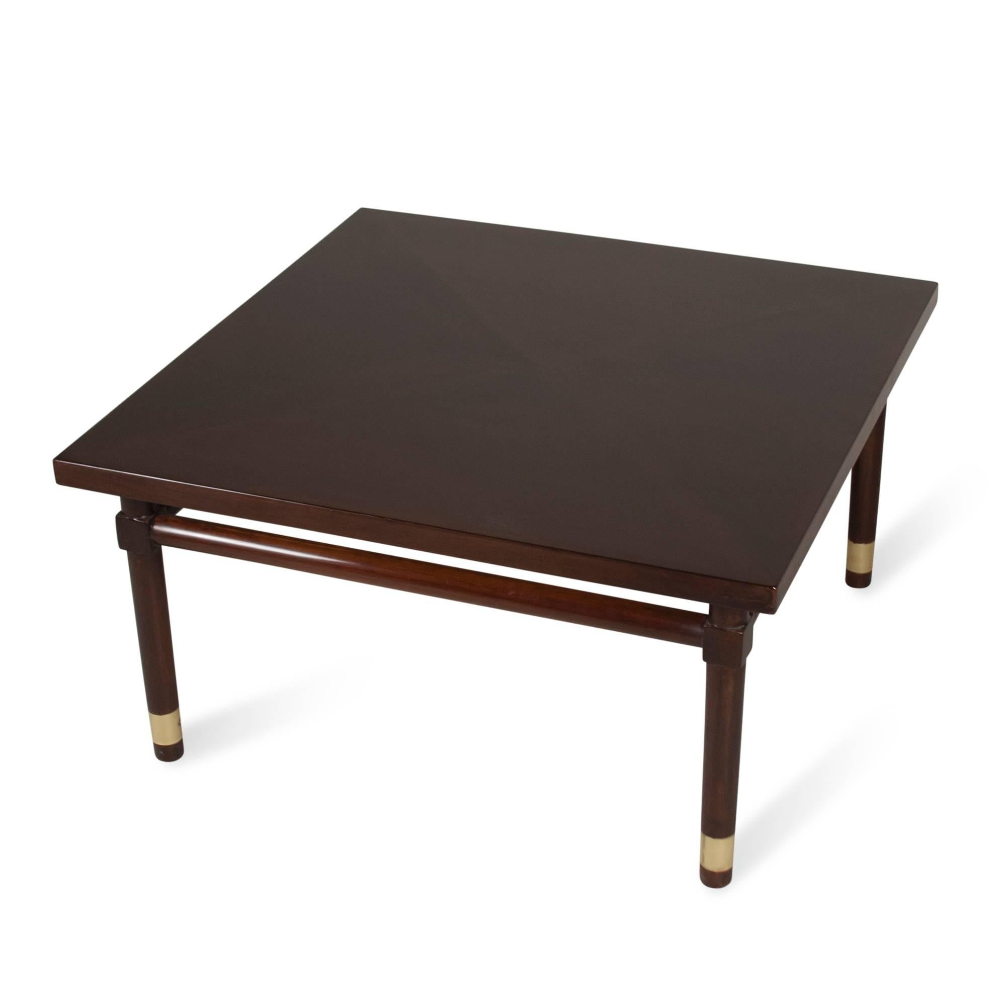 Solid mahogany square coffee table, rounded legs with brass band elements near the bottom, round stretchers between the legs, by Widdicomb, American, 1950s. Measures: 31 in square, height 16 1/2 in. (sats)