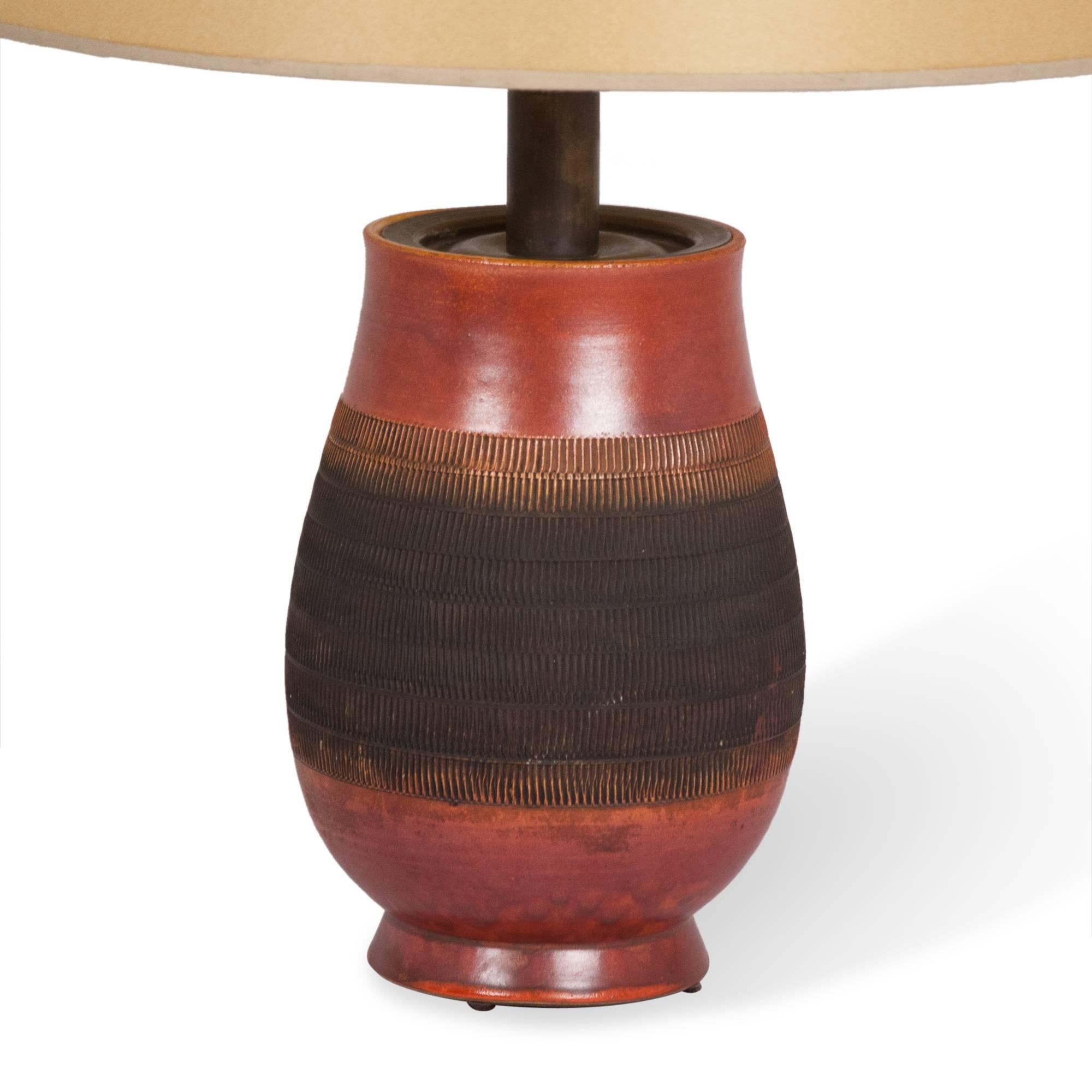 Ceramic table lamp, dark red glazed with wide textured band, French, 1930s. Measures: Overall height 21 in, diameter of shade 13 in, diameter of base 6 in.
 