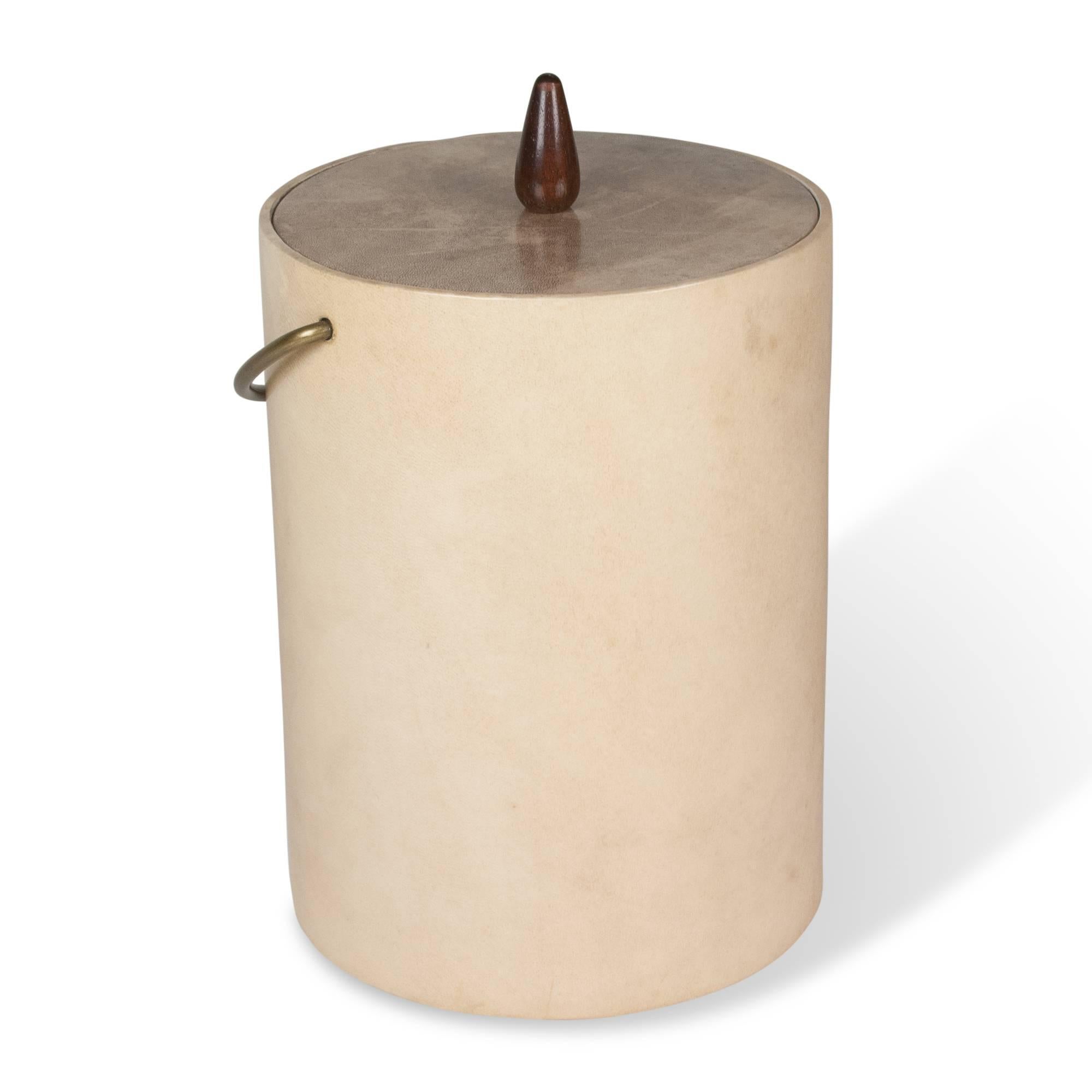 Dyed goatskin ice bucket, with brass handle, by Aldo Tura, Italian, 1960s. Plastic ice liner. Measures: Height to top of bucket 11 in, diameter 8 1/2 in. Height to top of raised handle 15 1/2 in.