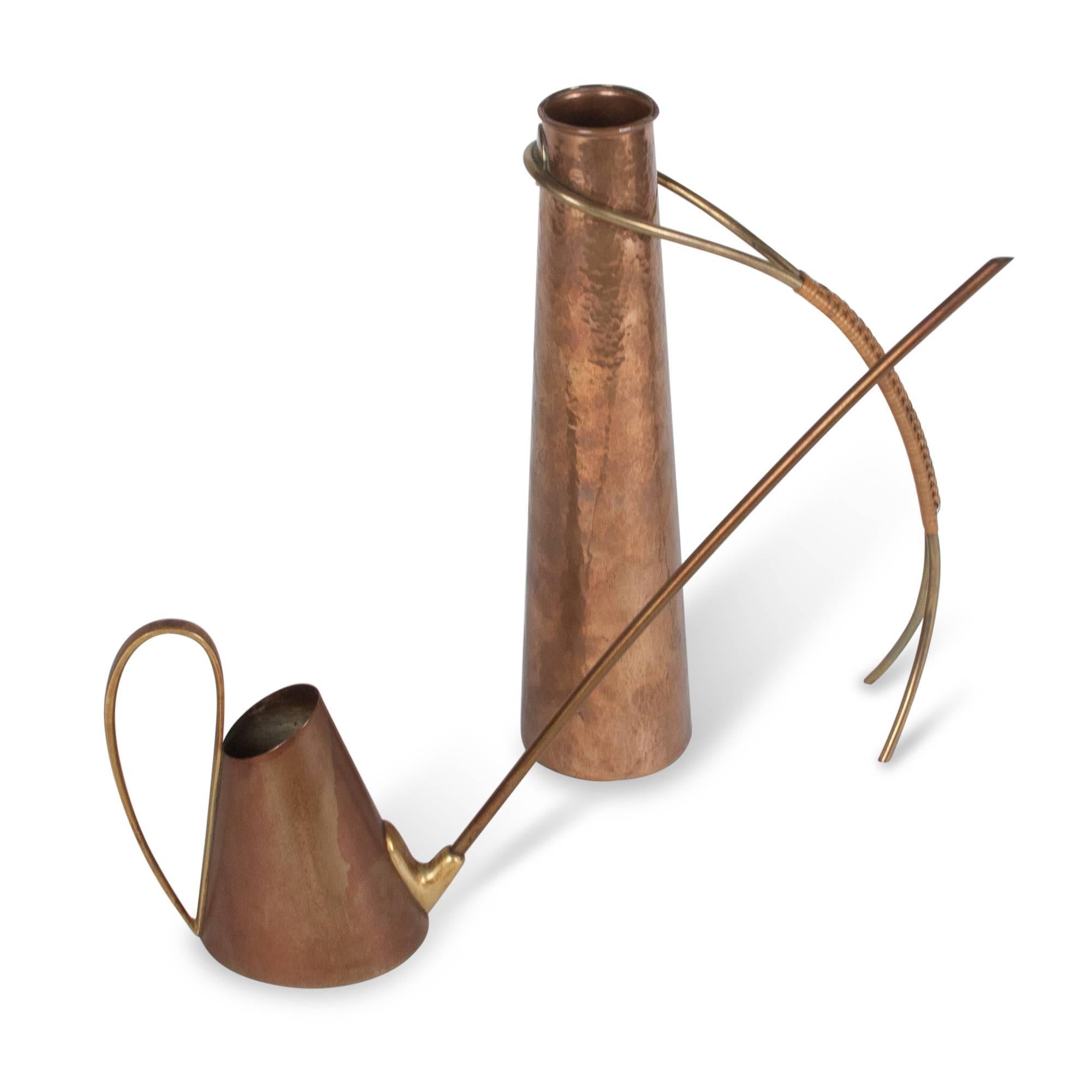 Two watering cans:
On left: Copper watering can, cone shaped body, with rounded handle and long spout, Austria, 1950s. Length from spout to handle 14 in, diameter at bottom 3 1/2 in, height to top of spout 10 in.  

On right: Hammered copper