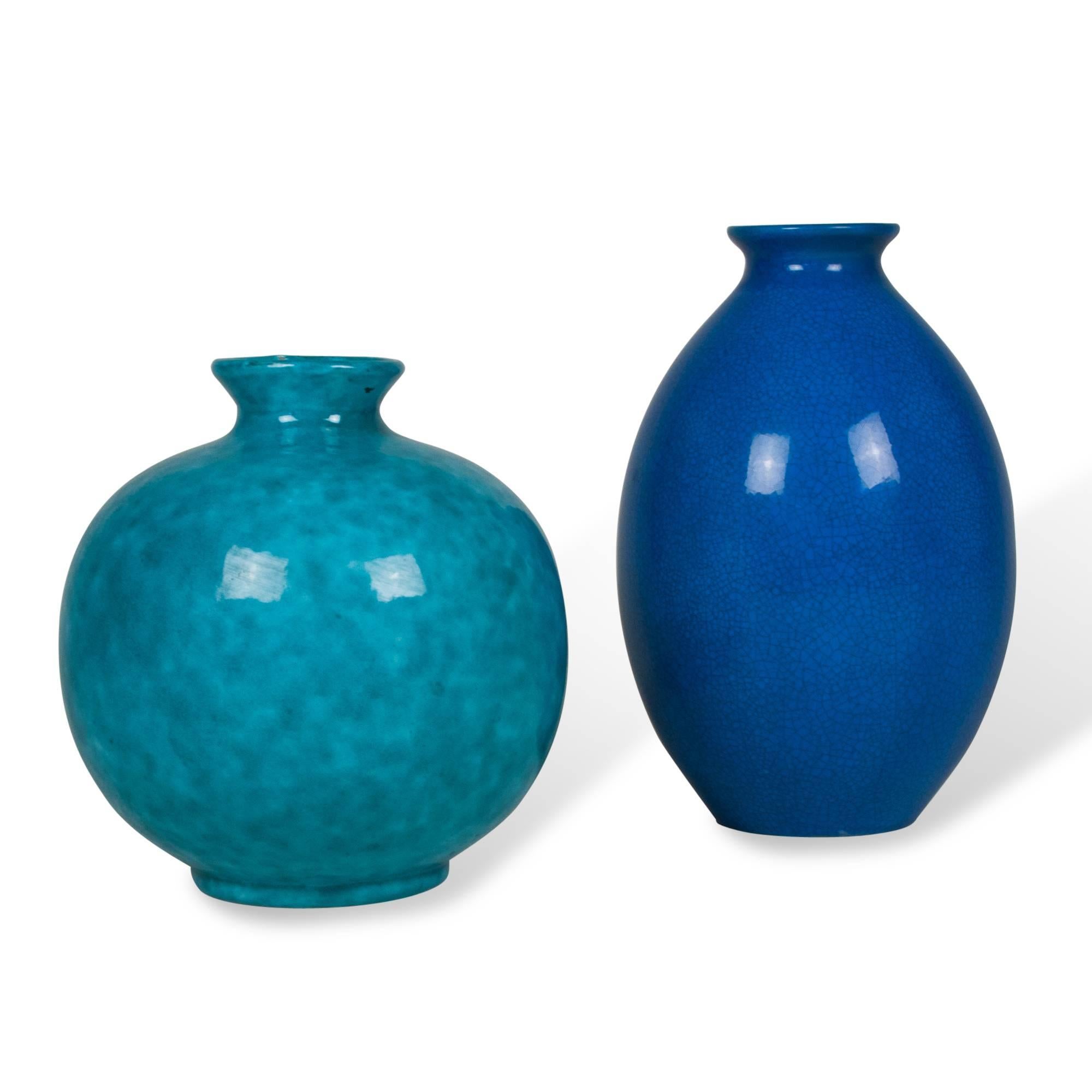 Set of two ceramic vases:
On left: Mottled blue glazed ceramic vase, spherical shape with pinched neck, by Jerome Massier, Vallauris, France, 1930s. Signed to underside. Height 10 in, largest diameter 8.5 in.

On right: Tall blue crackle glaze