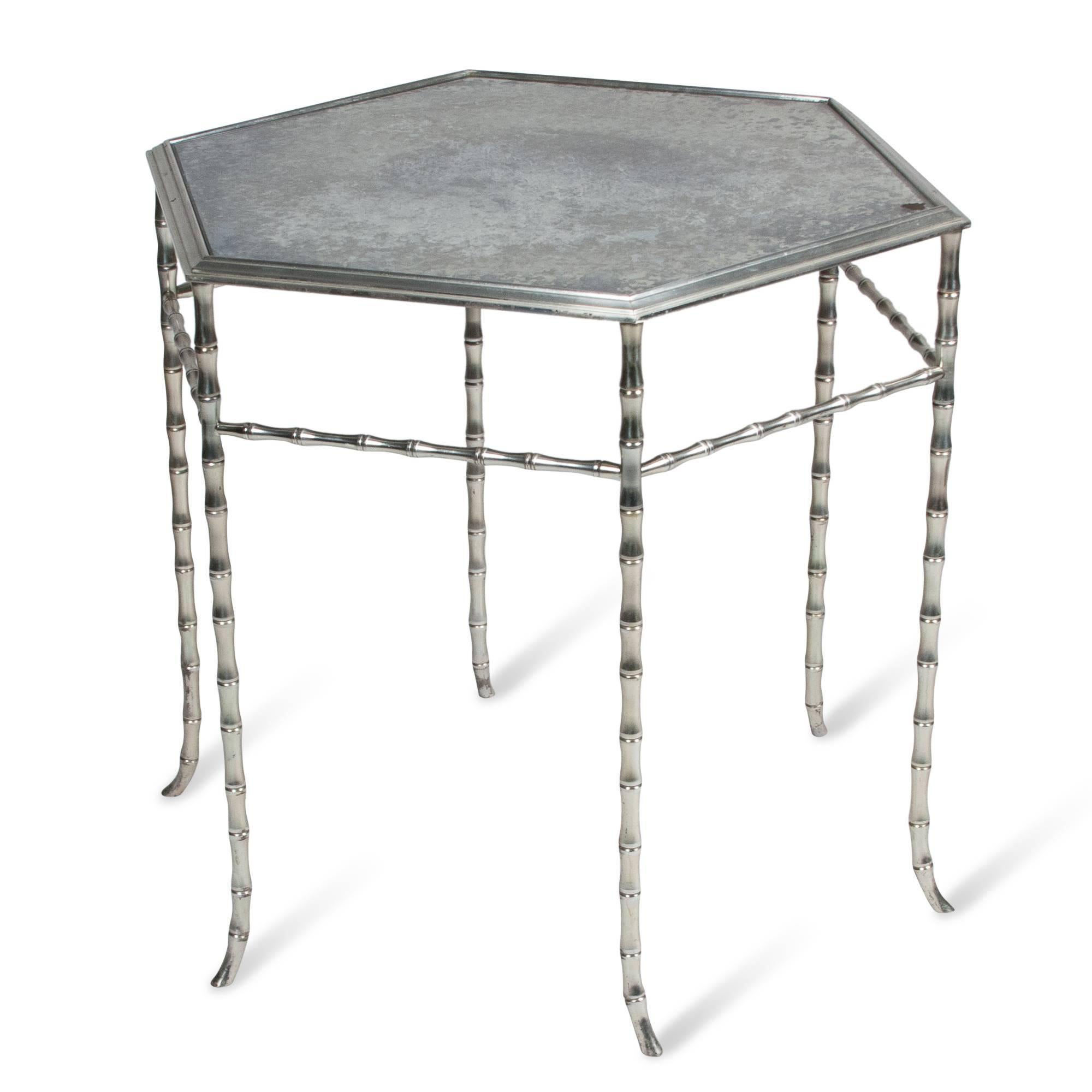 Chrome frame hexagonal shaped table, bamboo-style legs, antiqued mirrored glass top, by Bagues, France, 1960s. Measures: Width 21 1/2 in, height 21 1/2 in. Distance from point to point of hexagon 24 1/2 in.
