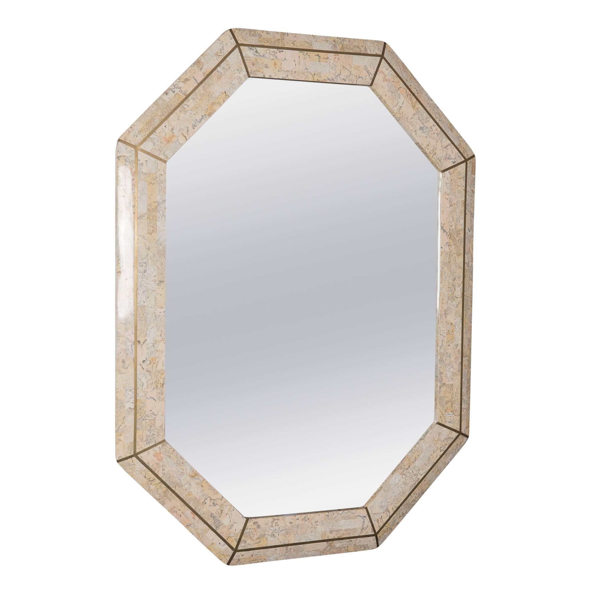 Tessellated stone frame mirror, octagonal form, with brass banded inlay, by Maitland Smith, England 1970s. Manufacturer label affixed to back. Measures: Height 40 1/4 in, width 30 1/4 in, depth 1 1/2 in. 
