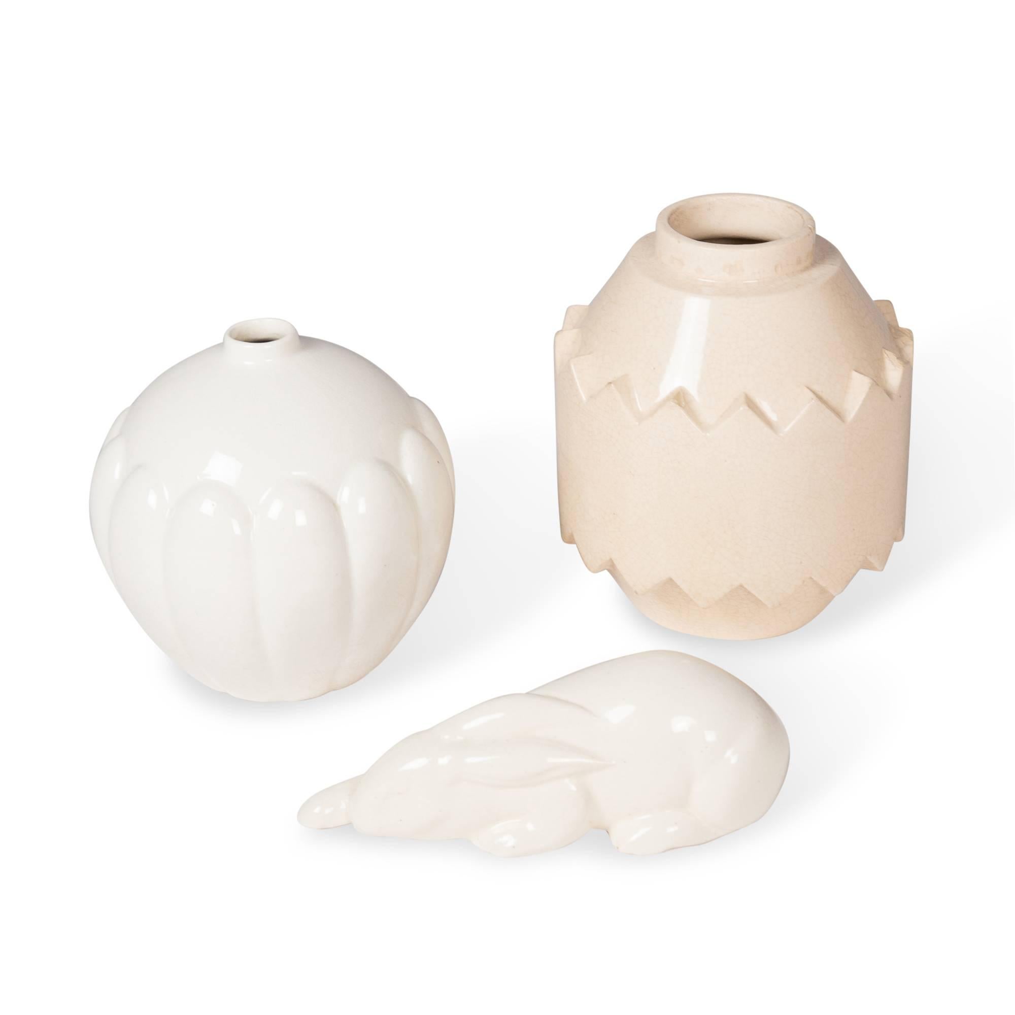 Set of three ceramics.
On left: Off-white crackle glaze ceramic vase, bulbous form with lobed sides, narrow opening, by St. Clement, France 1930s. Measures: Height 7 1/2 in, diameter 7 1/2 in.
On right: Beige crackle glaze ceramic vase, of