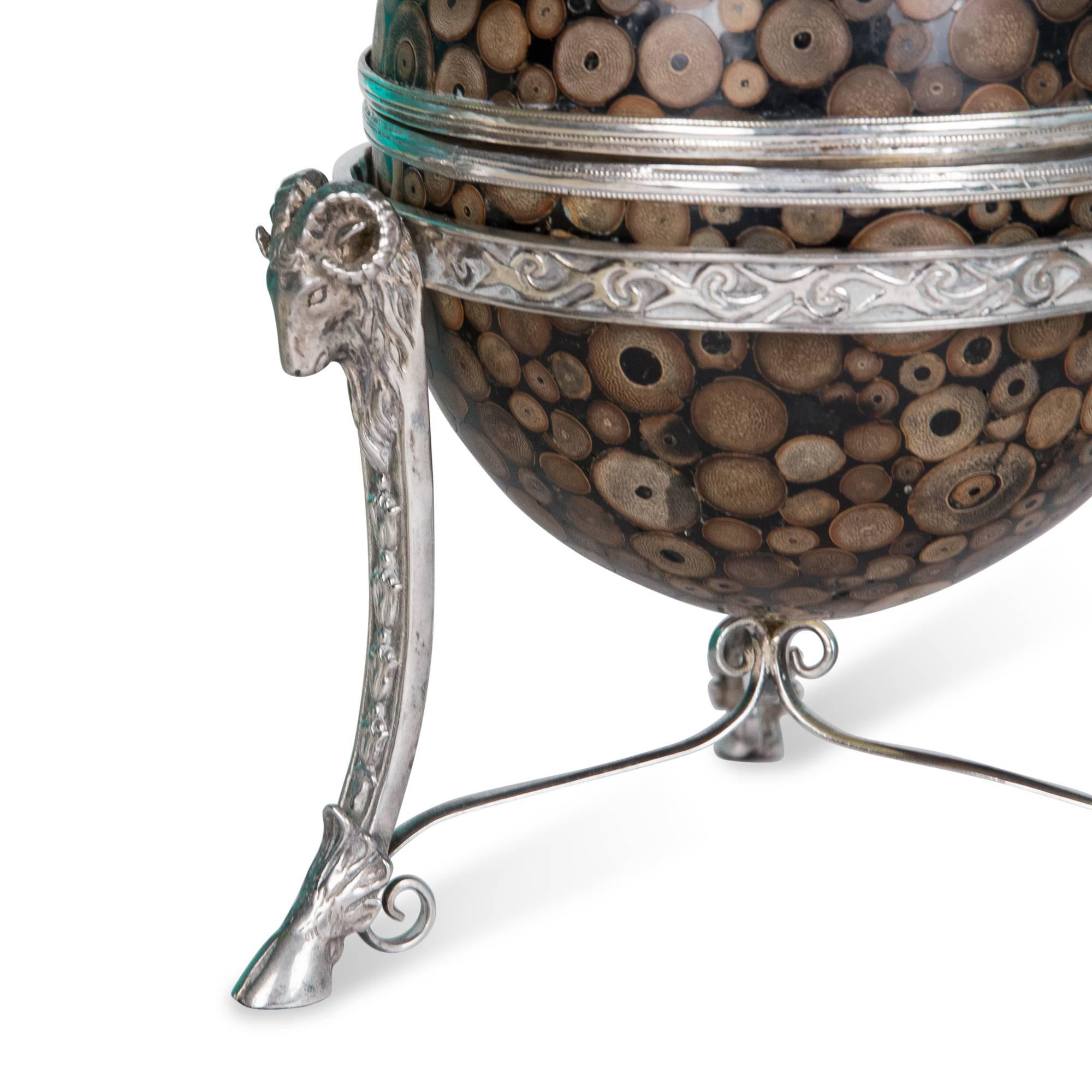 Egg form box, with inlaid exotic wood slices, silver plated detail, on silver plate Stand decorated with rams' head and hooves, velvet lined. By Maitland-Smith, United Kingdom, 1970s. Measures: Height 10 1/2 in, diameter 8 in.
   