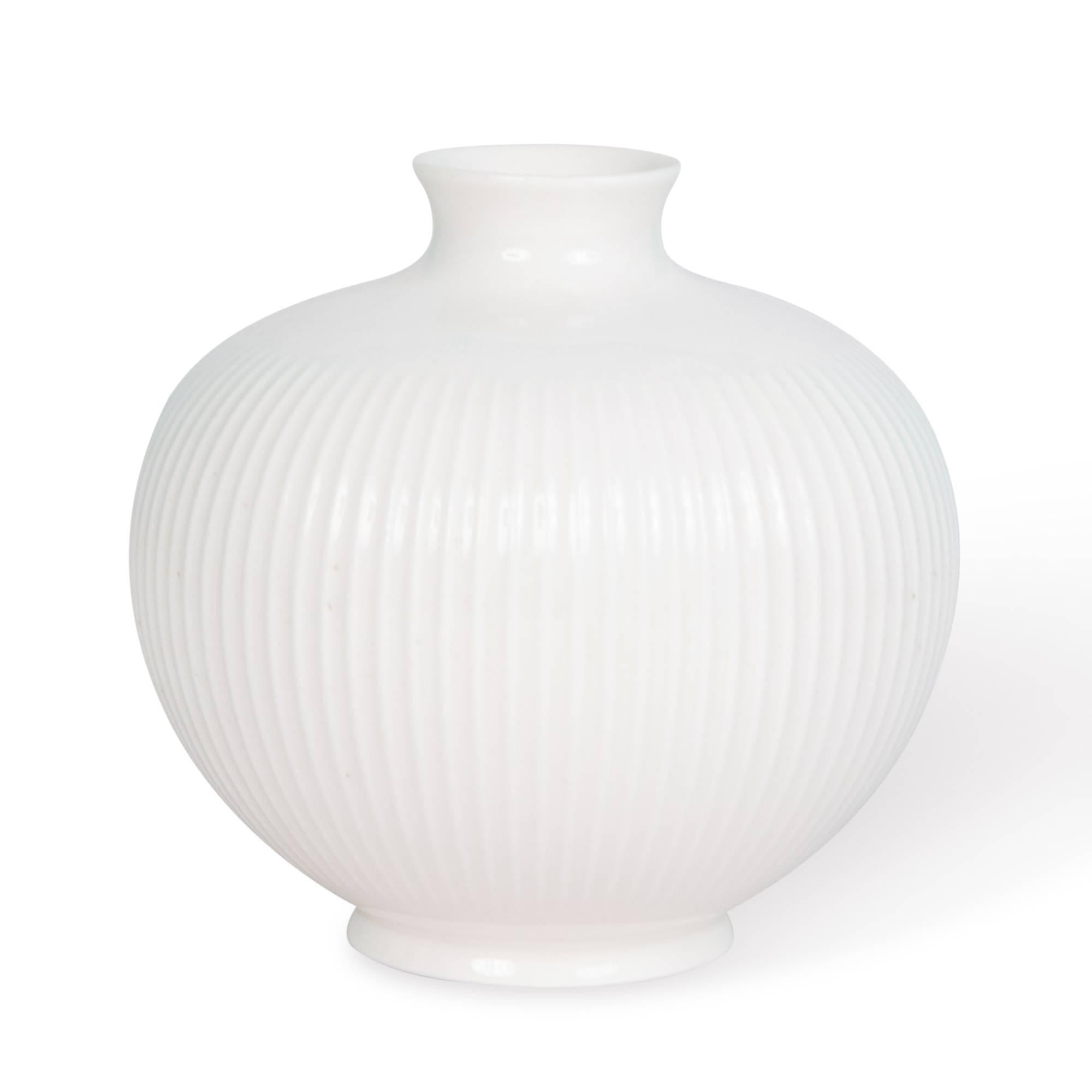 Porcelain bulbous form vase, with grooved sides and flared rim, by Royal Copenhagen, Denmark, 1960s. Measures: Height 4 in, diameter 4 1/2 in.
      
