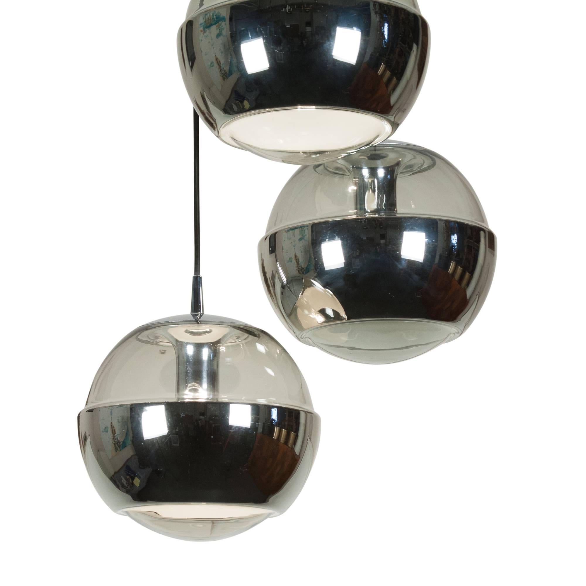 Silver glass three-light hanging chandelier, each sphere having a smoky glass upper half, the lower half with applied interior silver foil, by Peill and Putzler, German, 1960s. Each sphere has diameter of 12 1/2 in. Overall height 40 in.