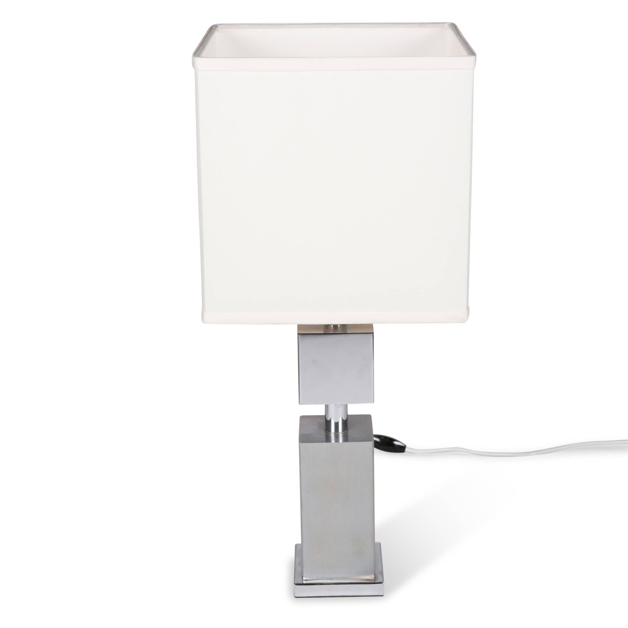 Chrome table lamp, square column based with superposed chrome cube, France, 1970s. Overall height 23 1/2 in, base measures 4 in square. Shade measures 10 in x 10 in, shade height 10 in.