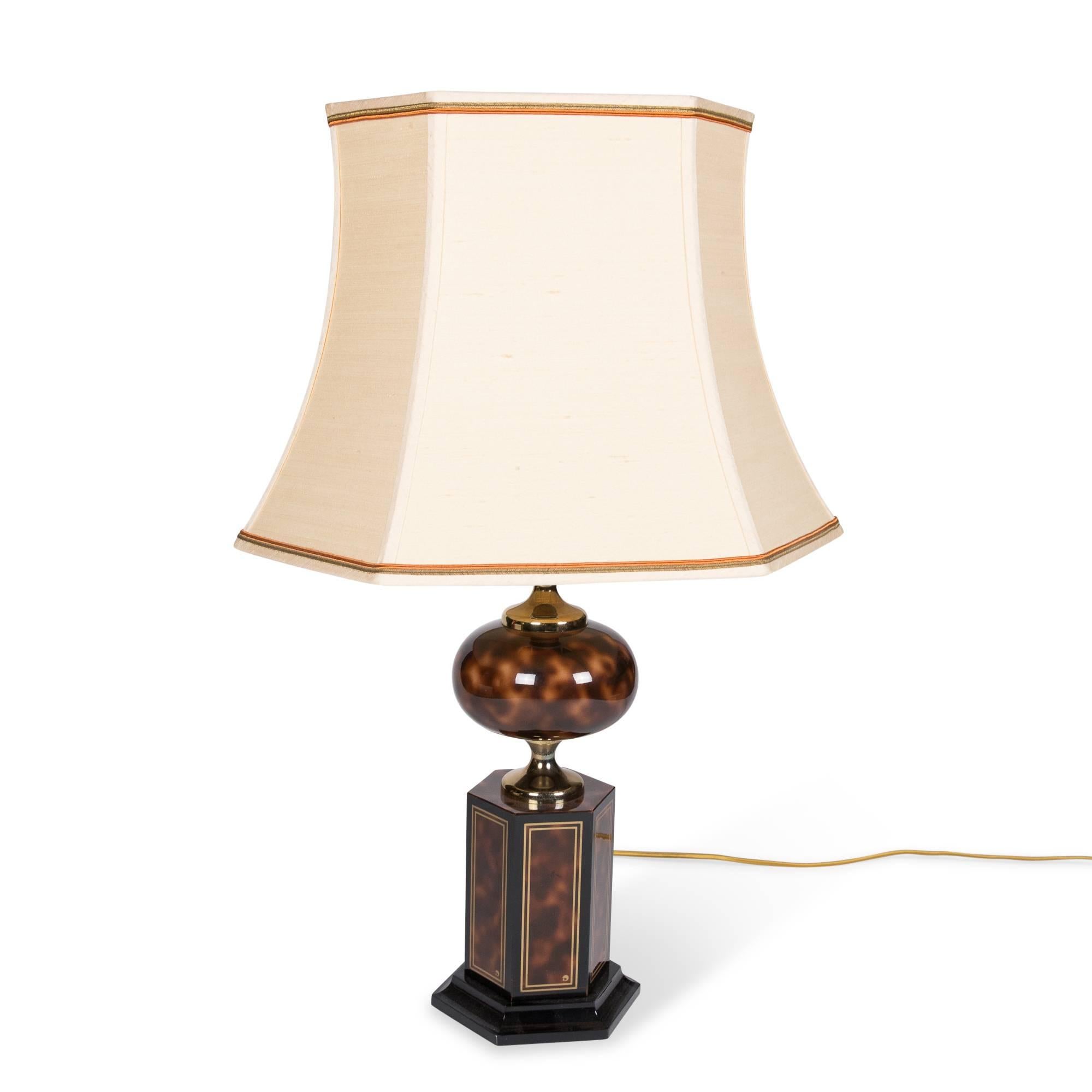 Faux tortoiseshell table lamp, with spherical element above hexagonal base, gold trim, on black lacquer base by Maison Jansen, France, 1970s. In original shade, overall height 26 1/2 in. Base measures 6 3/4 in x 6 in. Shade measures width 17 3/4 in,