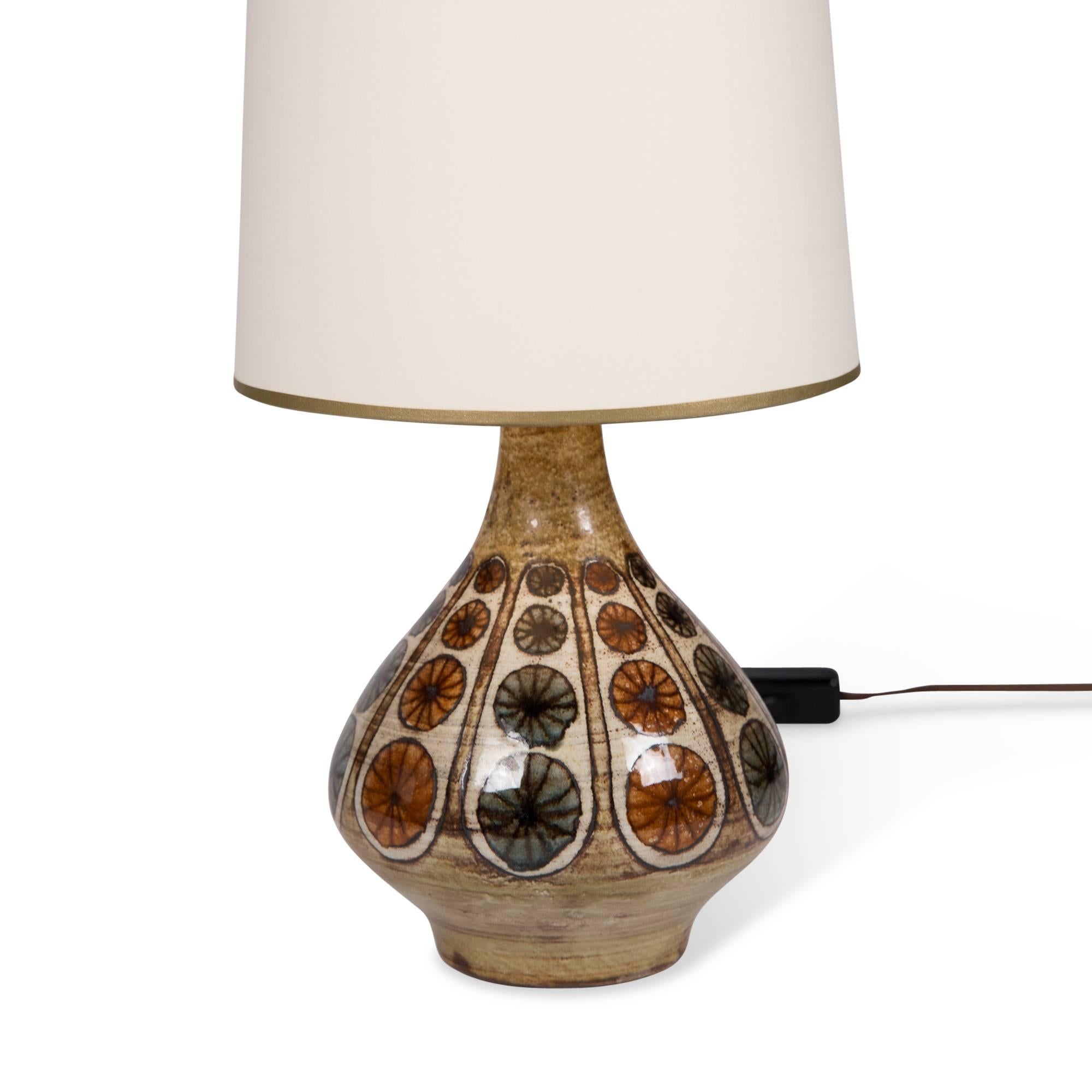 Ceramic table lamp, pale glazed ceramic with colored geometric decoration, by Jean Malarmey, France, 1960s. Measures: Overall height 16 1/2 in, diameter of base 5 1/2 in. Shade measures top dia 6 1/2 in, bottom dia 8 in, height 9 in.