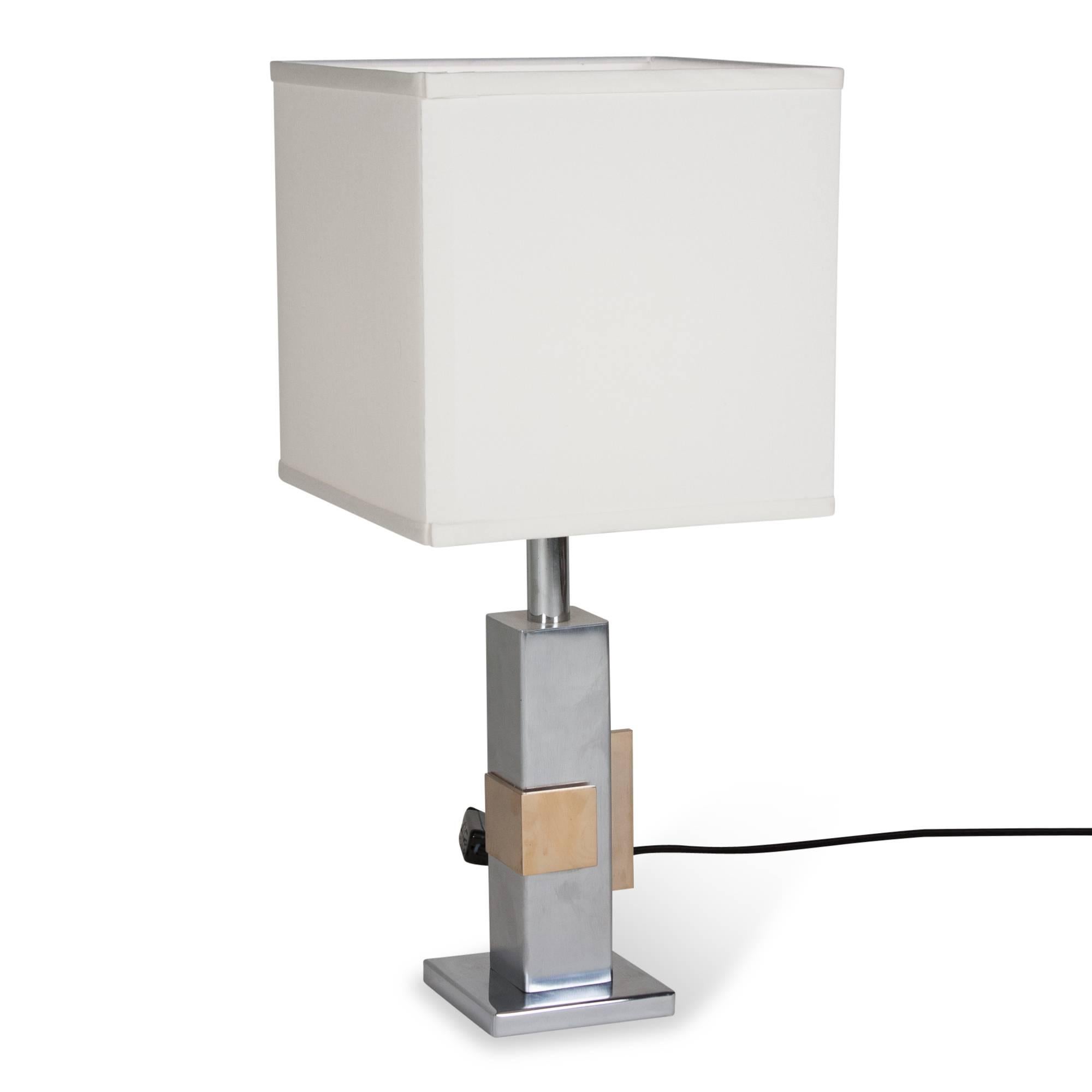 Chrome and bronze table lamp, the square chrome column having two applied bronze geometric elements, French, 1970s. Measures: Overall height 22 1/2 in, base measures 4 3/4 in square. Shade measures 10 in cubed.
         