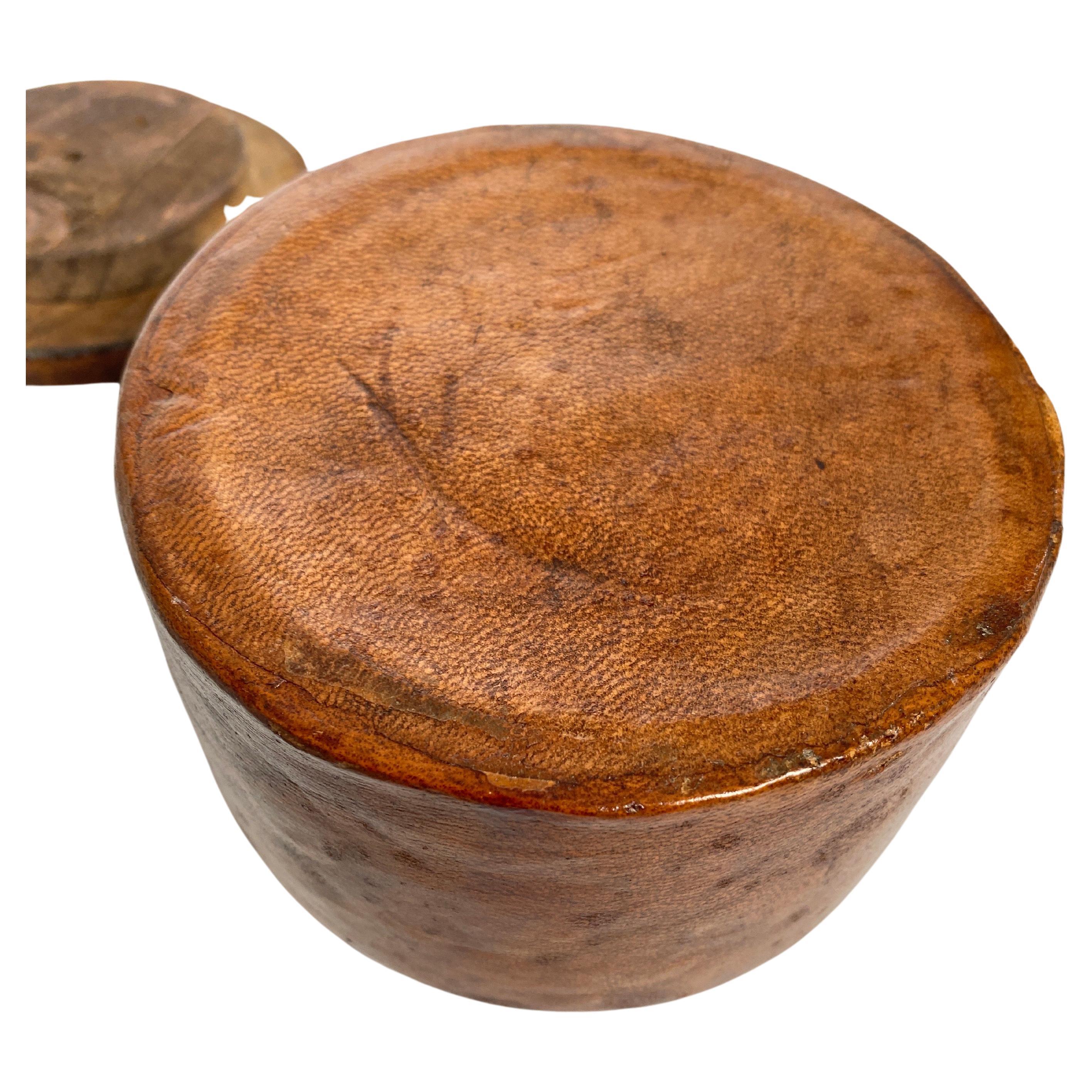 This snuffbox, or tobacco box, covered with leather, brown in color. The underside of the lid is made of wood, and the inside of the pot is ceramic. The object has been signed by the artist. It was made in France in the 1940s, it was during the