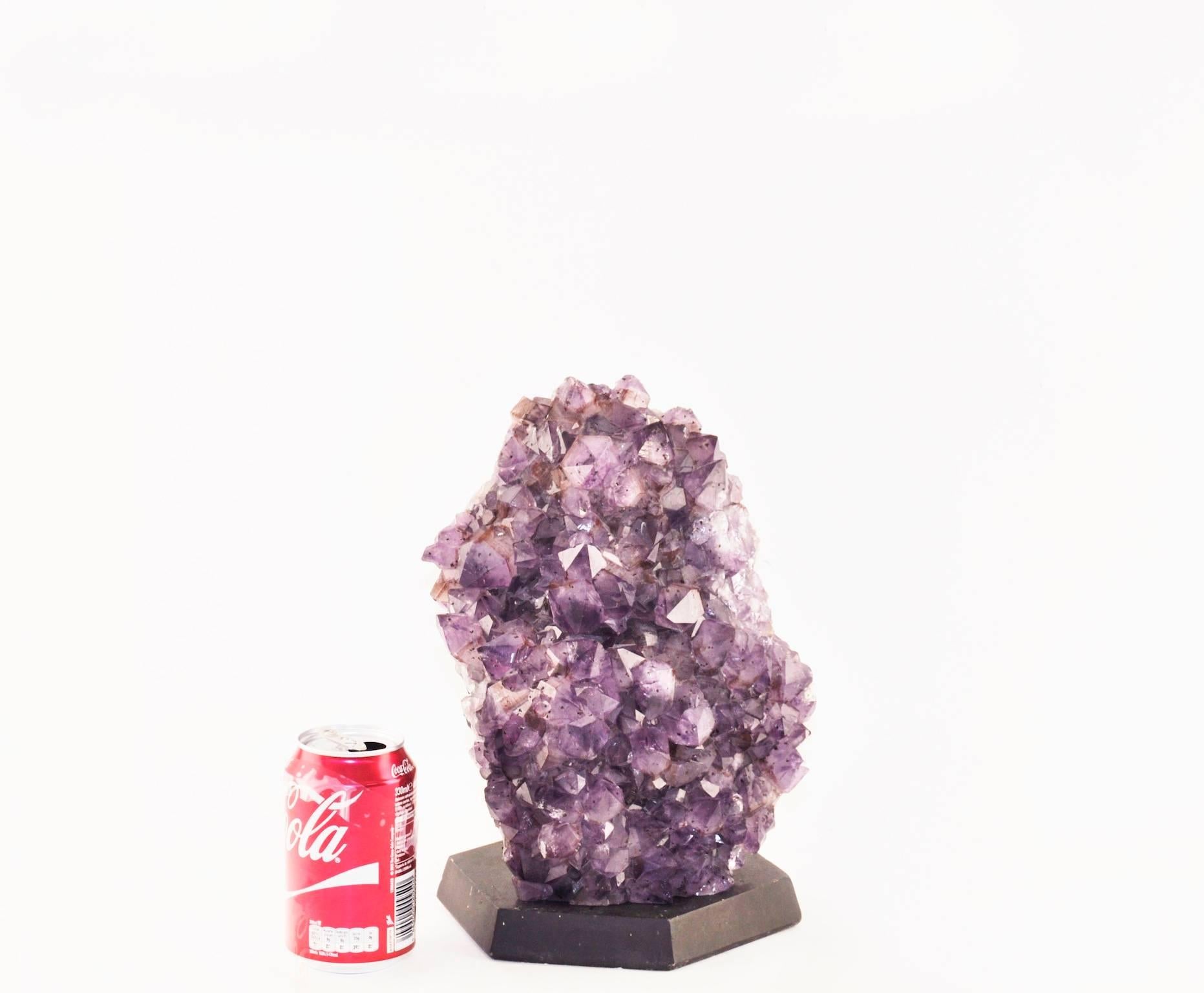 A substantial Amethyst mounted on a wood base.