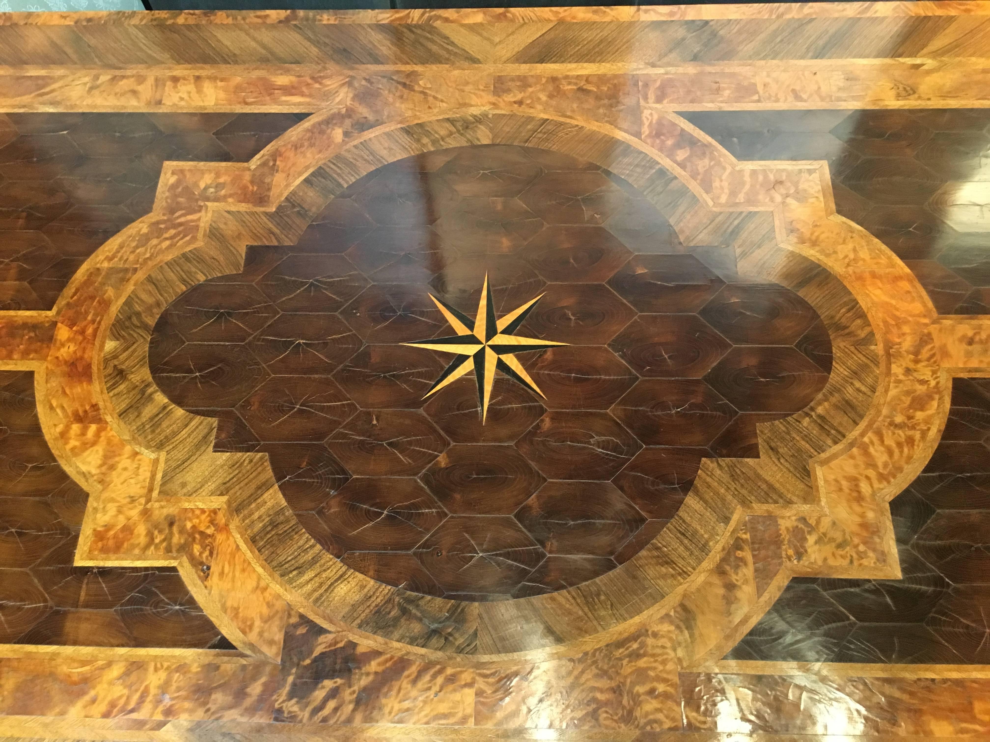 A simply gorgeous George III marquetry inlaid extension dining table in the Italian taste. Stunning inlays of mahogany, fruitwood, satinwood and ebony. The center cartouche of neoclassical design centered around an eight pointed star medallion, upon
