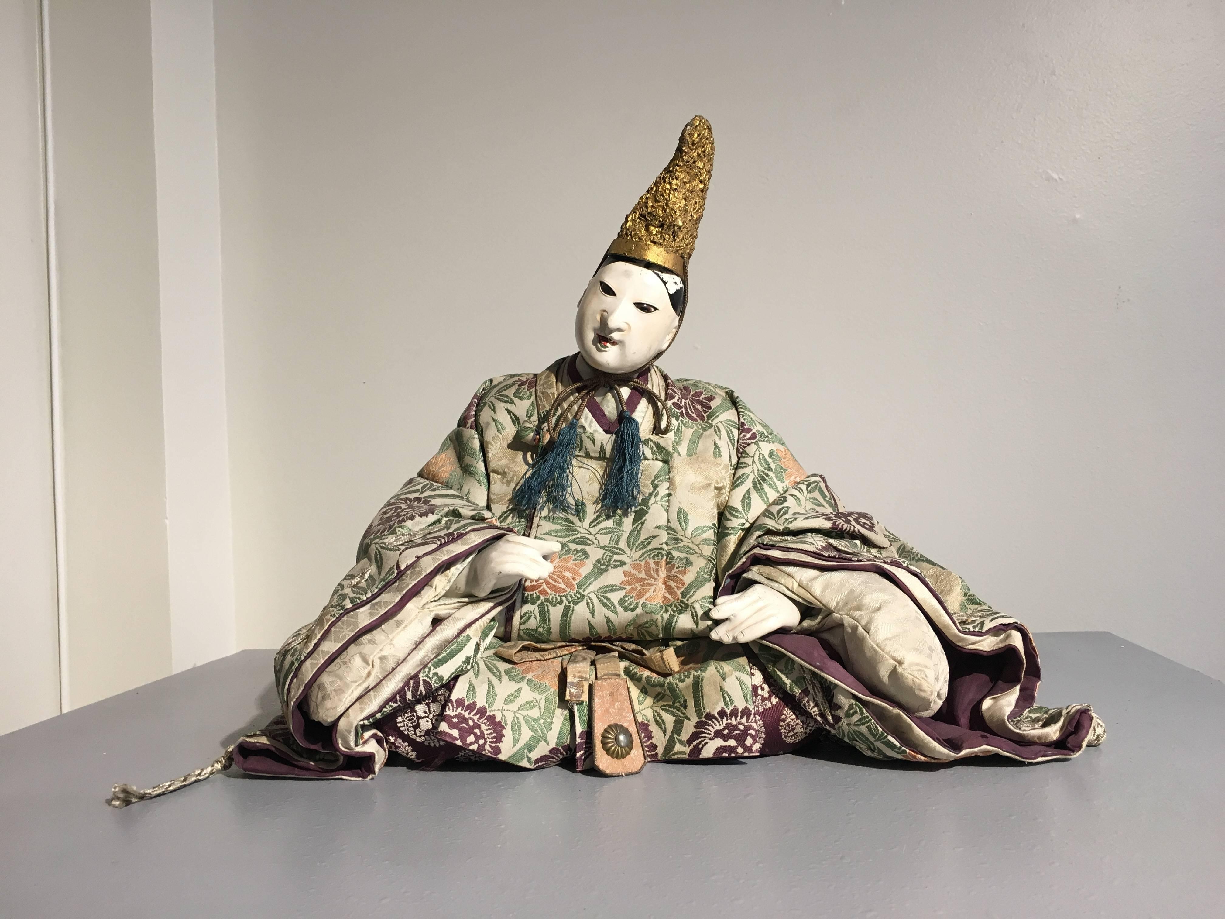 Zwei exquisite japanische Musha-Ningyo-Puppen als Höflinge, Edo-Periode, frühes 19. Jahrhundert, Japan. 
Der ältere Mann kann als die historische Figur Takenouchi no Sukune identifiziert werden, ein vertrauenswürdiger Hofberater der Kriegerkaiserin