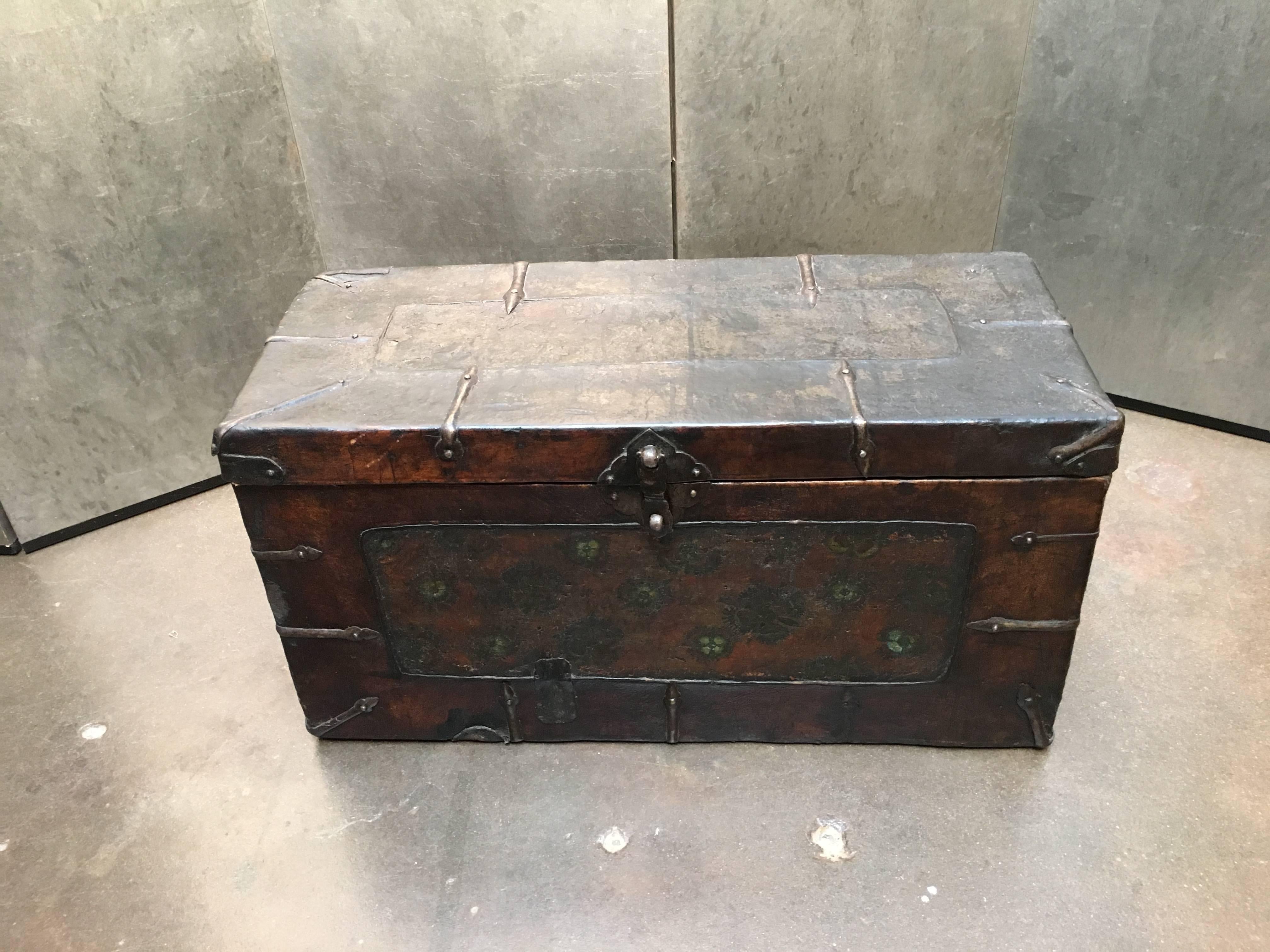 A charming Tibetan painted leather storage trunk, 18th century, Tibet. 

Of smaller size, the softwood construction of the trunk covered by a richly tanned yak leather. The central panel, also of leather, painted in a floral motif, somewhat