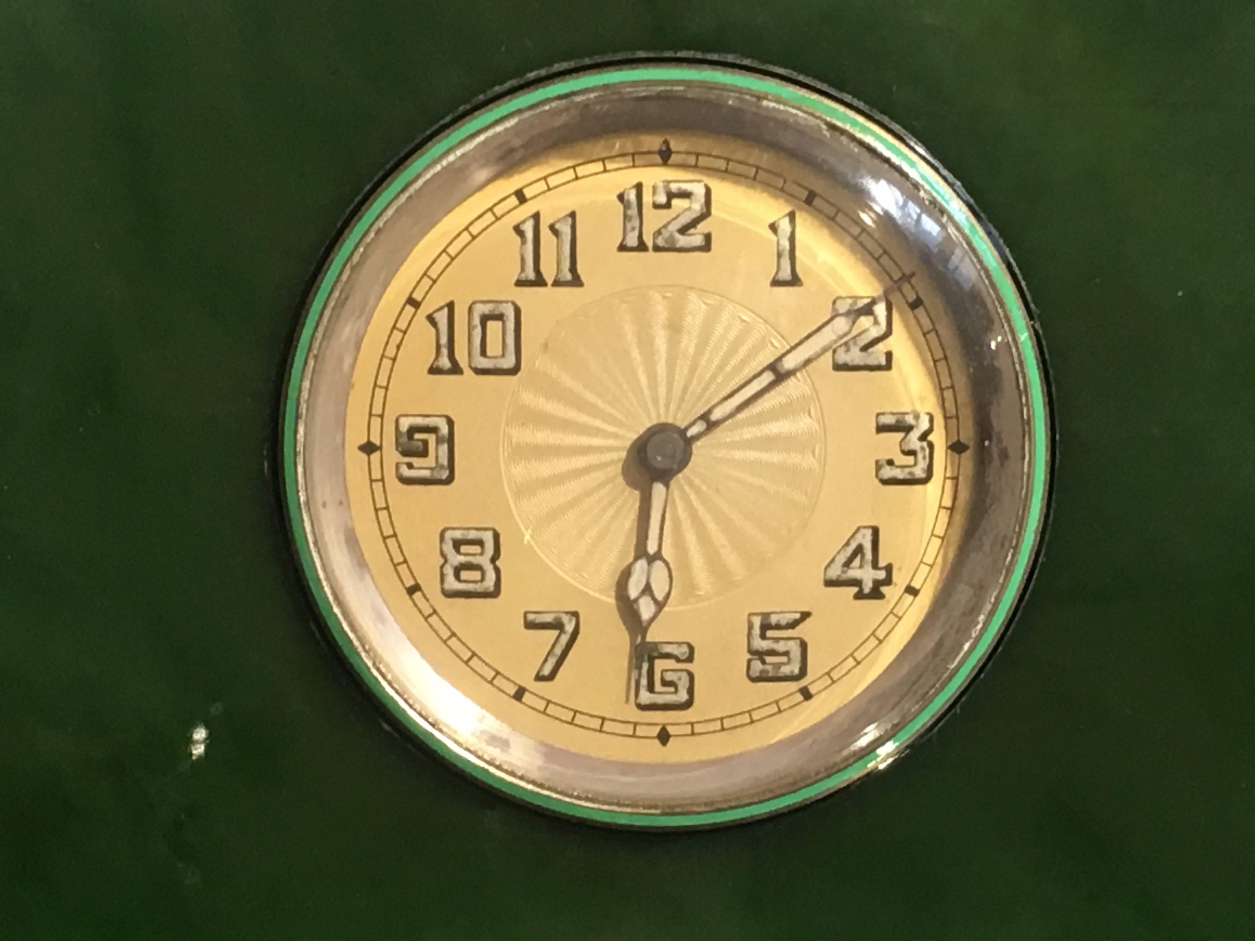 Une horloge de bureau Art Déco en forme de fronton, tout simplement élégante.
Le boîtier et le mouvement sont de Lemania continental, sertis dans un boîtier en jade néphrite vert épinard, et montés en argent sterling avec des rehauts d'émail vert
