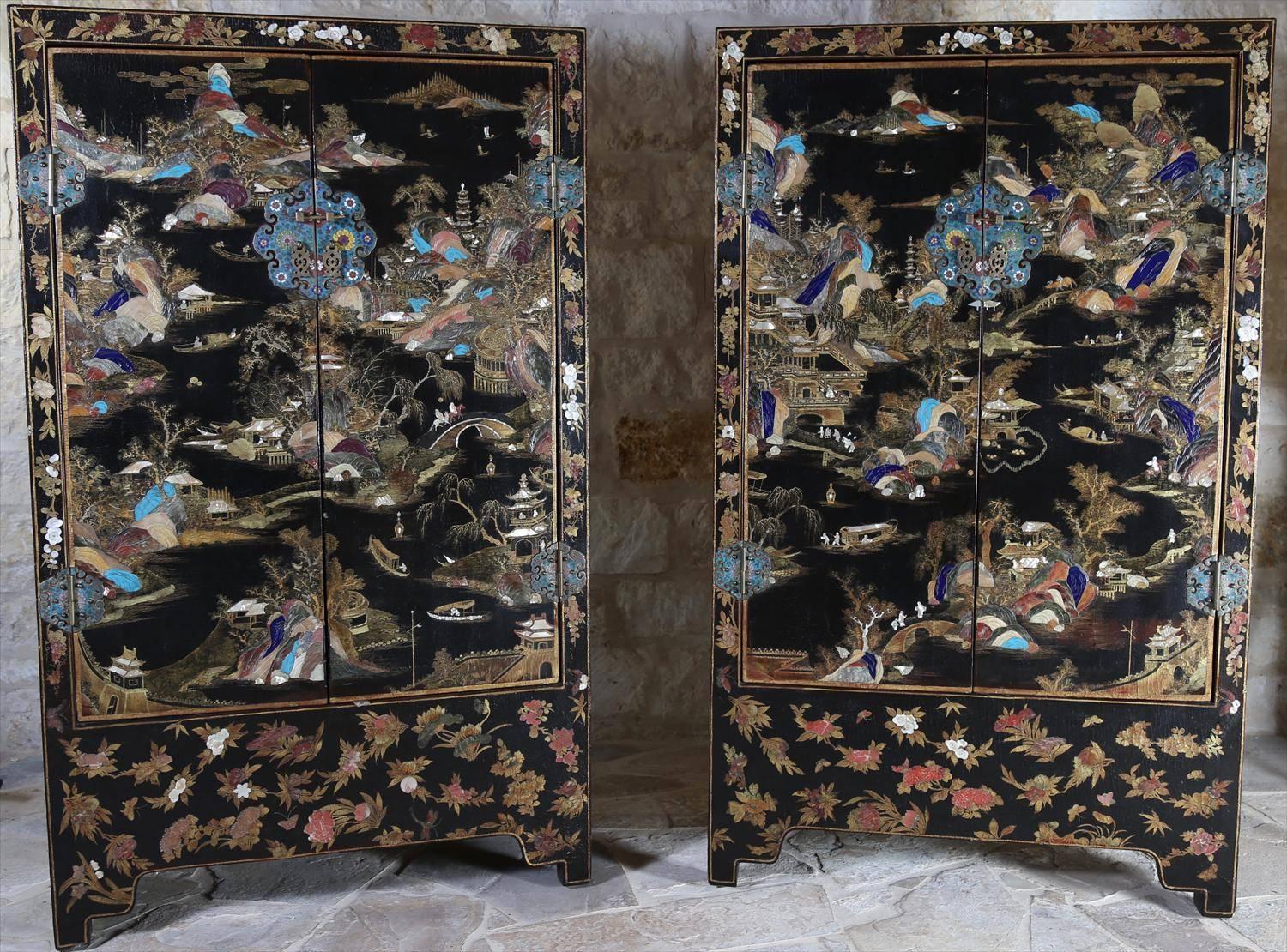 A pair of Qing dynasty early 19th century Chinese lacquer and hardstone inlaid cabinets, circa 1820, Jiaqing or Daoguang period.
This stunning pair of cabinets features a large black lacquer and gilt painted landscape scene, continuing across all