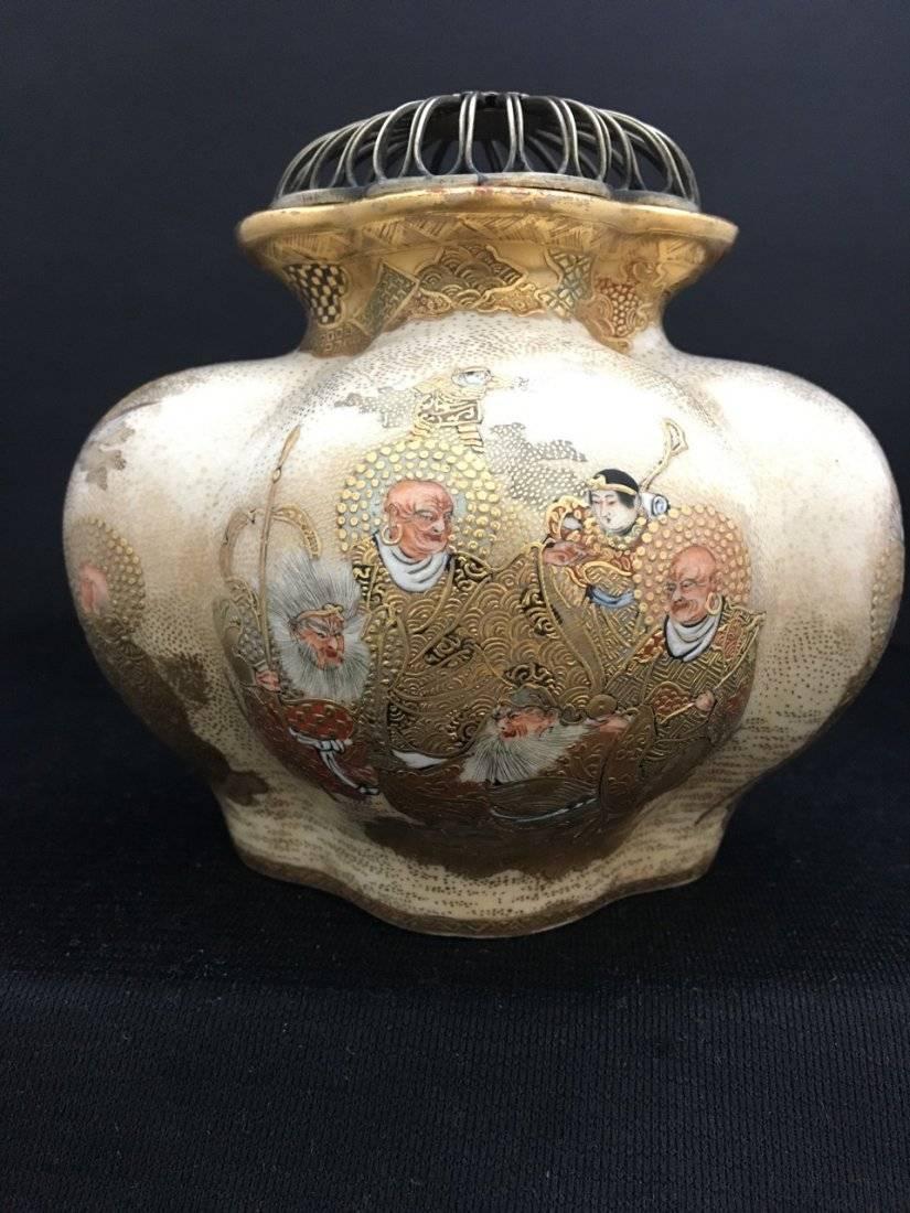 A finely painted Satsuma incense burner, or koro, with original silver cover.
The lobed body of quatrefoil form, painted in relief in typical Satsuma fashion with an overall gold palette on a cream ground, featuring figures of the 16 arhats, Juroku
